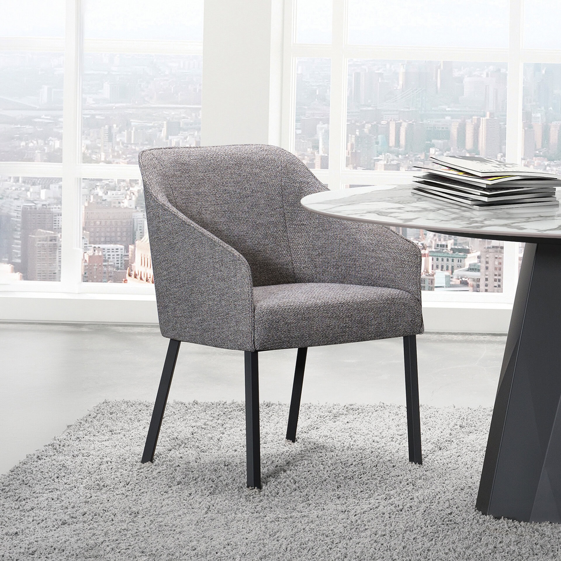 Stylish grey office chair with black legs in a modern office setting.