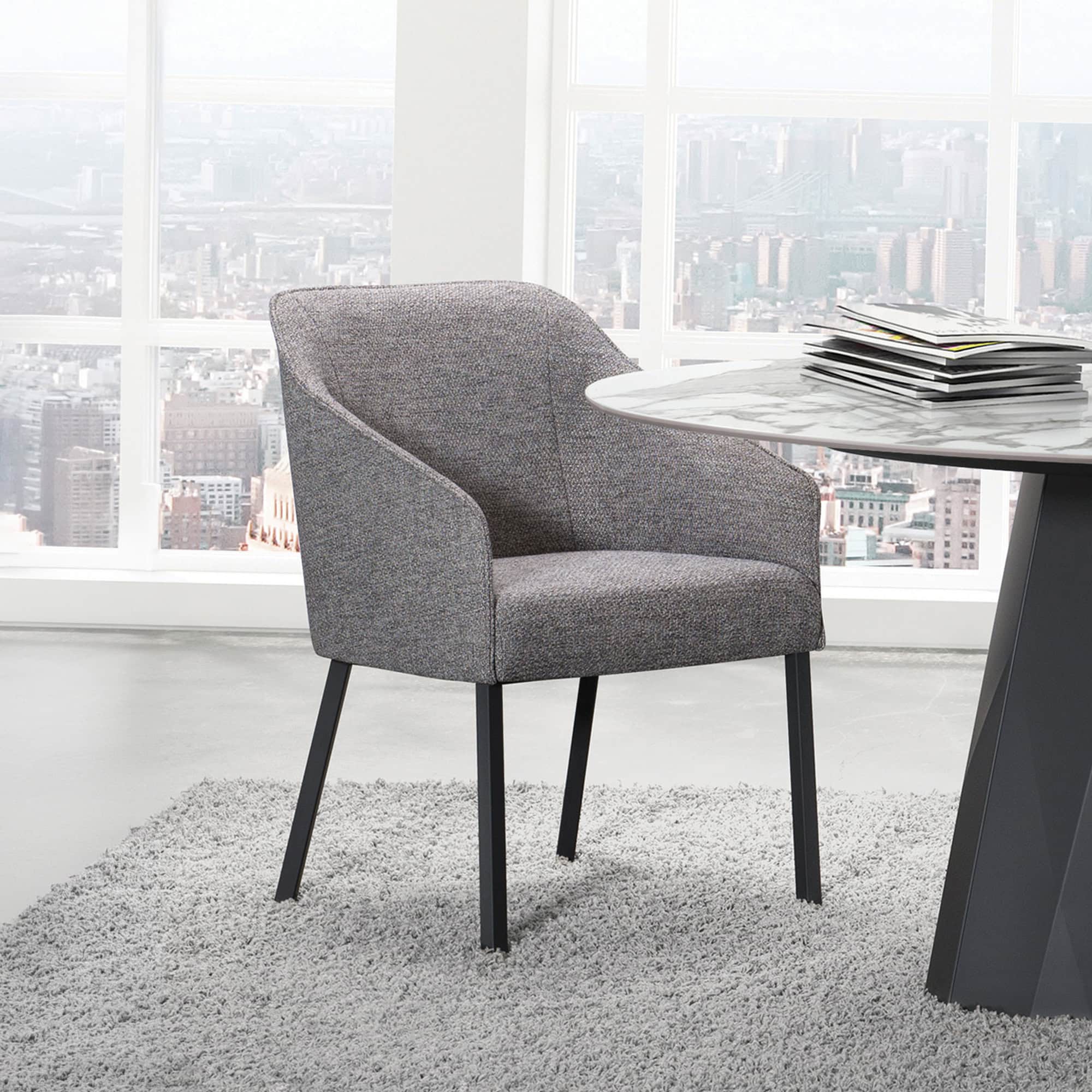 Stylish grey office chair with black legs in a modern office setting.