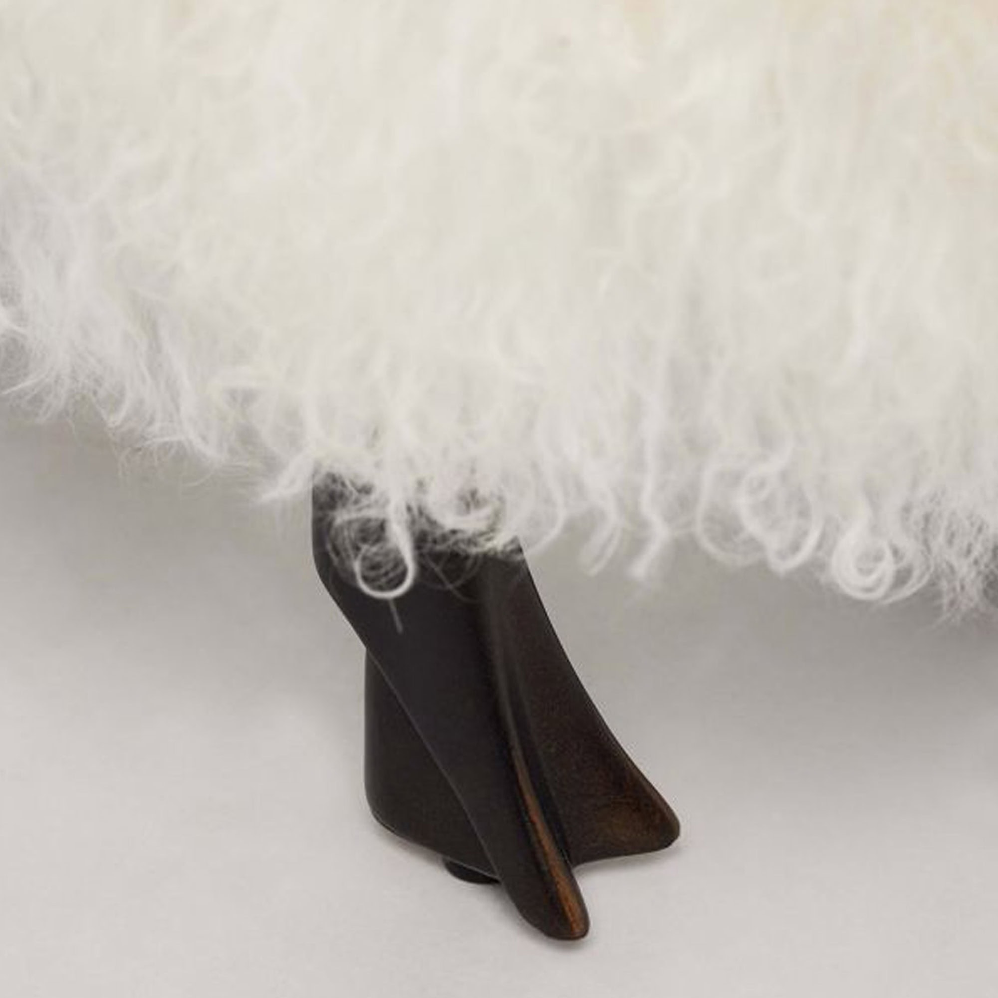 Close-up of antique bronze legs on the Lucie Baby Sheep Statue upholstered in ivory sheepskin.