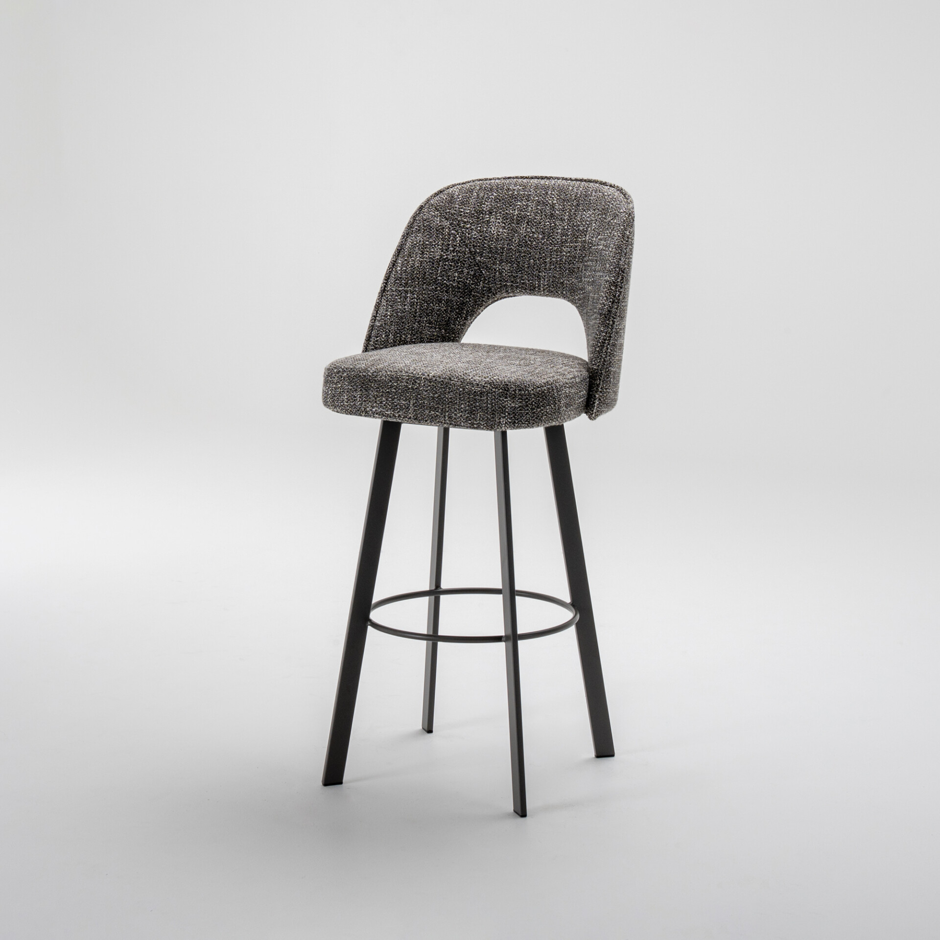 A modern dark grey upholstered bar stool with a cutout backrest and black metal legs on a light grey background.