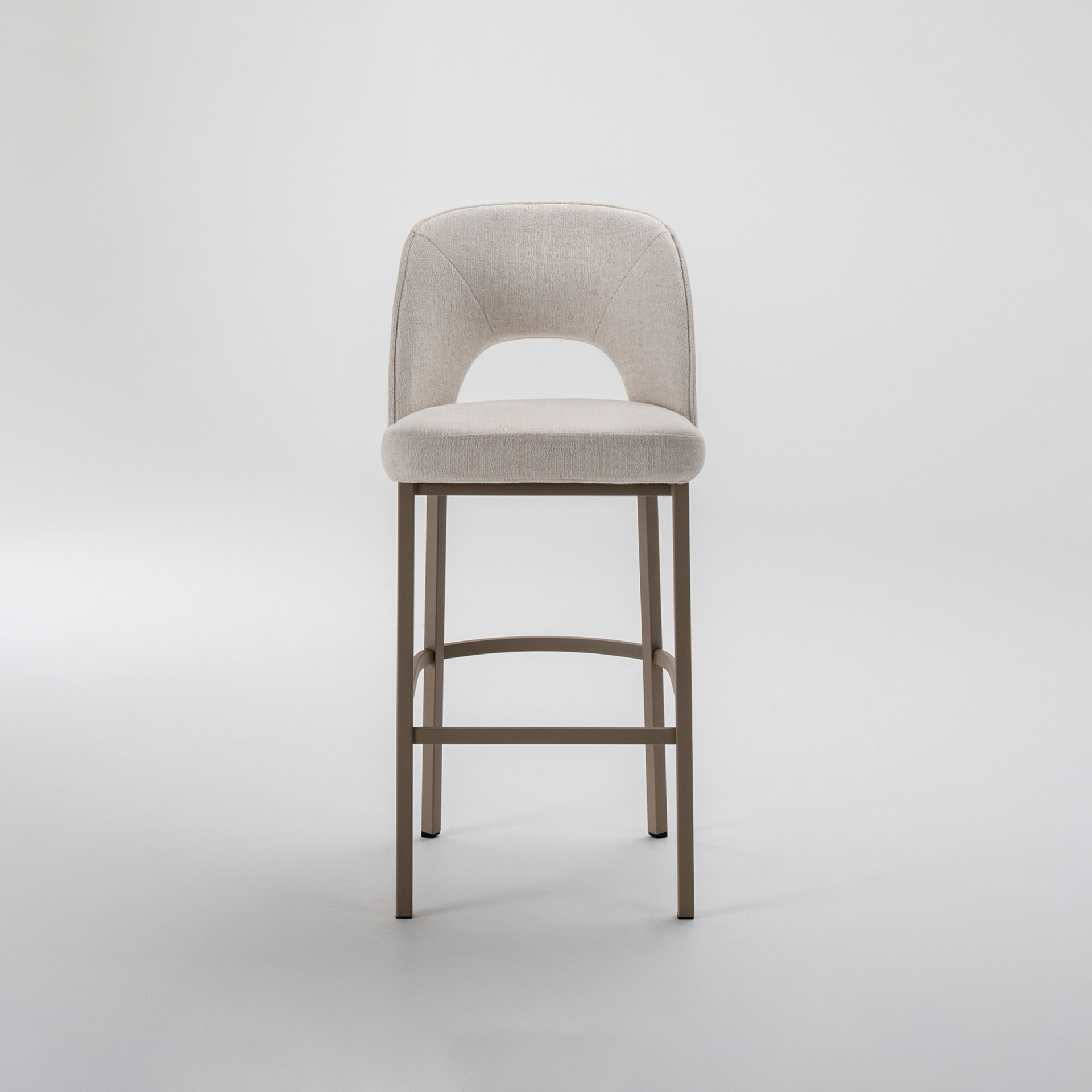 A modern bar stool with light beige fabric upholstery and a distinctive cut-out backrest, on a matte taupe metal frame, against a white background.