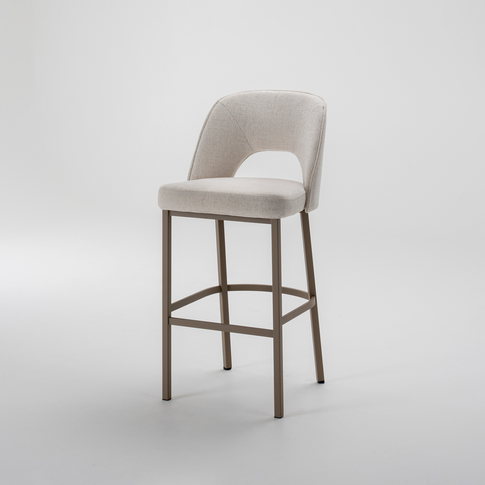 A modern bar stool with light beige fabric upholstery and a curved backrest with a cutout, set on a matte brown metal frame, against a white background.