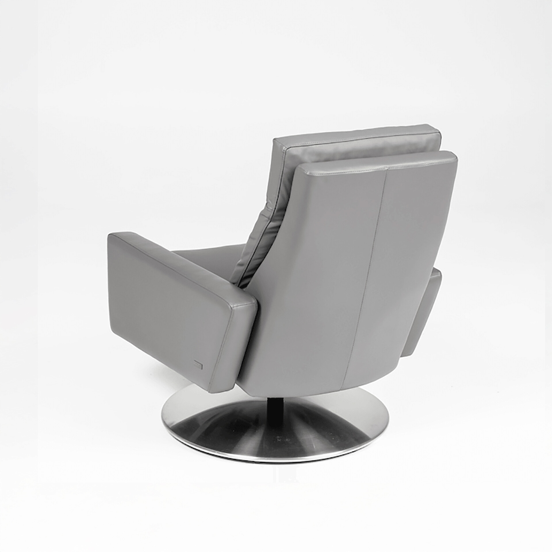 A modern, grey leather-look swivel armchair with a brushed metal disc base, viewed from a three-quarter rear angle against a white background.