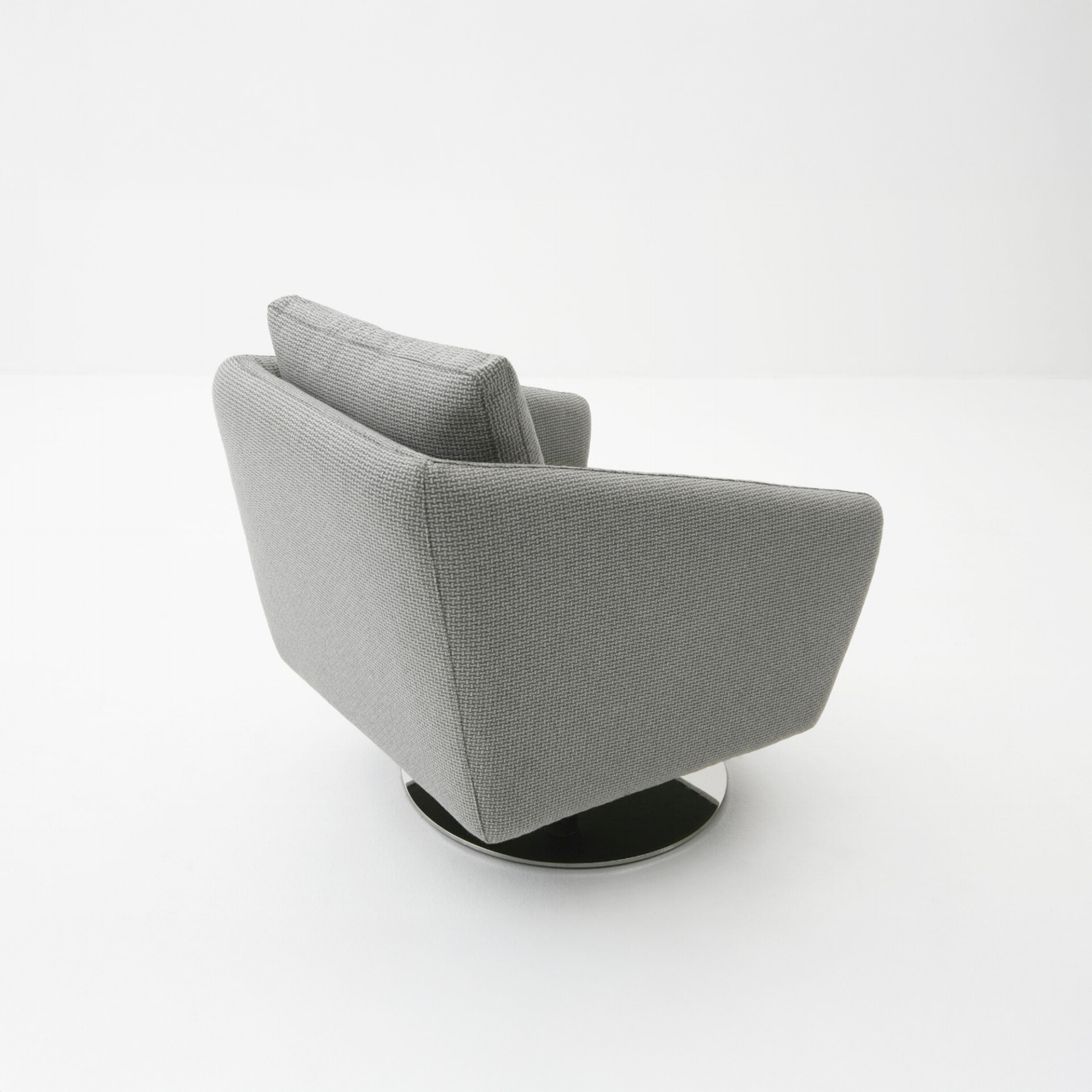 A modern light gray armchair with a textured woven fabric and a polished chrome swivel base, viewed from the back-right on a white background.