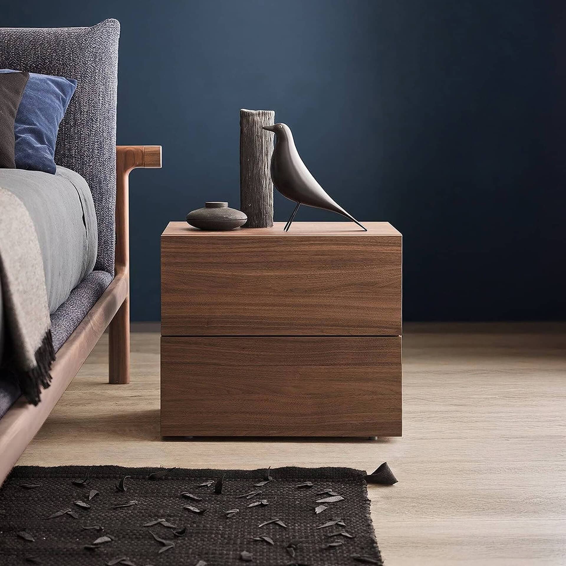 Elegant nightstand featuring a bird sculpture and minimalist vases for contemporary bedroom decor.