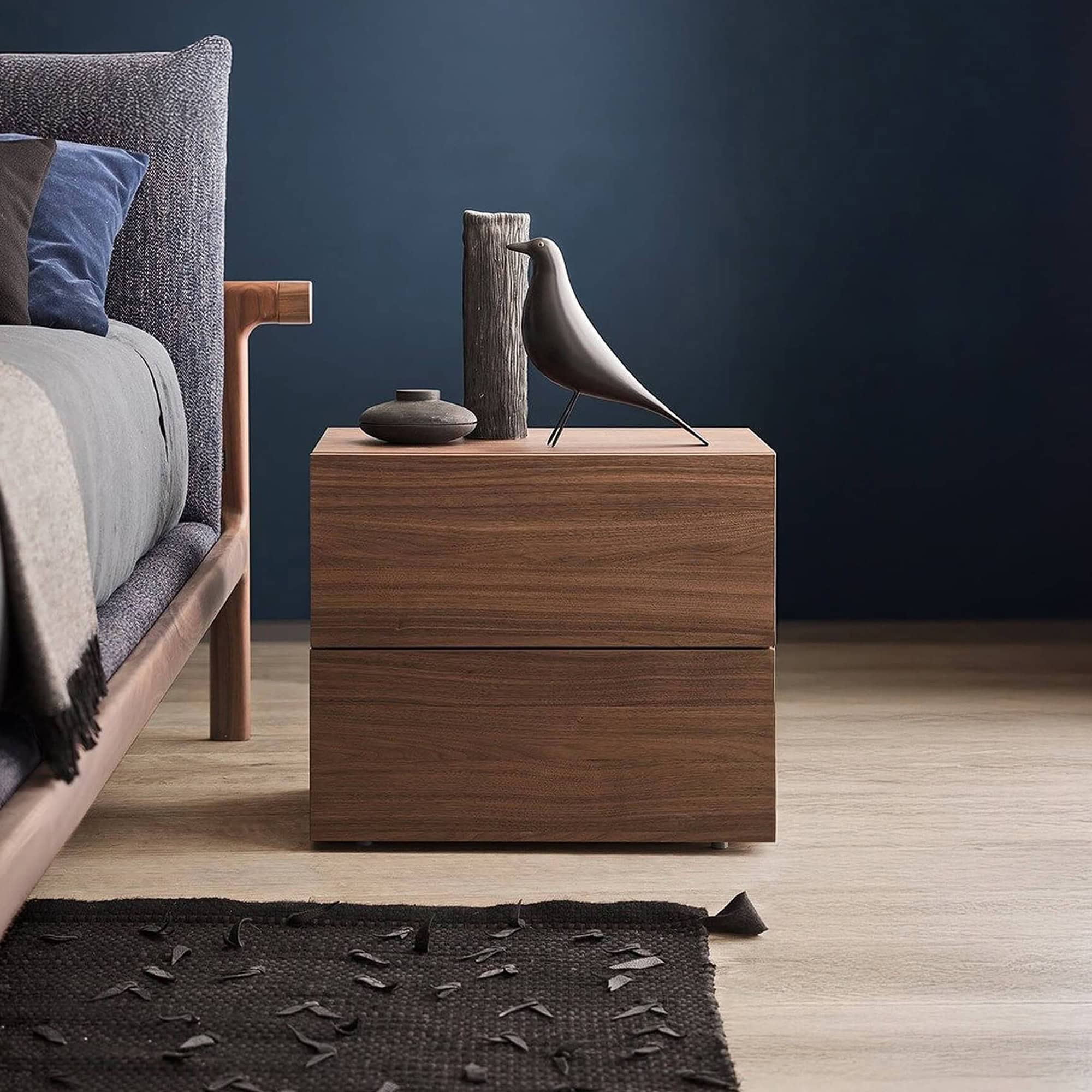 Elegant nightstand featuring a bird sculpture and minimalist vases for contemporary bedroom decor.