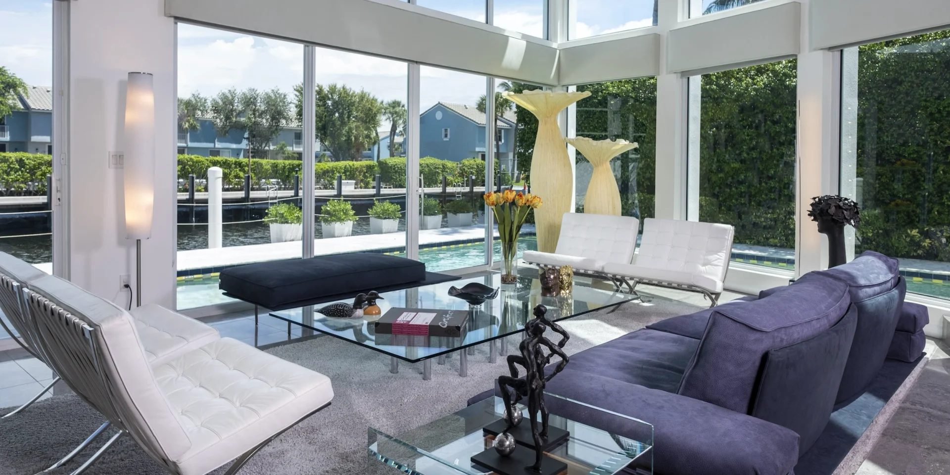 A living room with large windows and furniture.