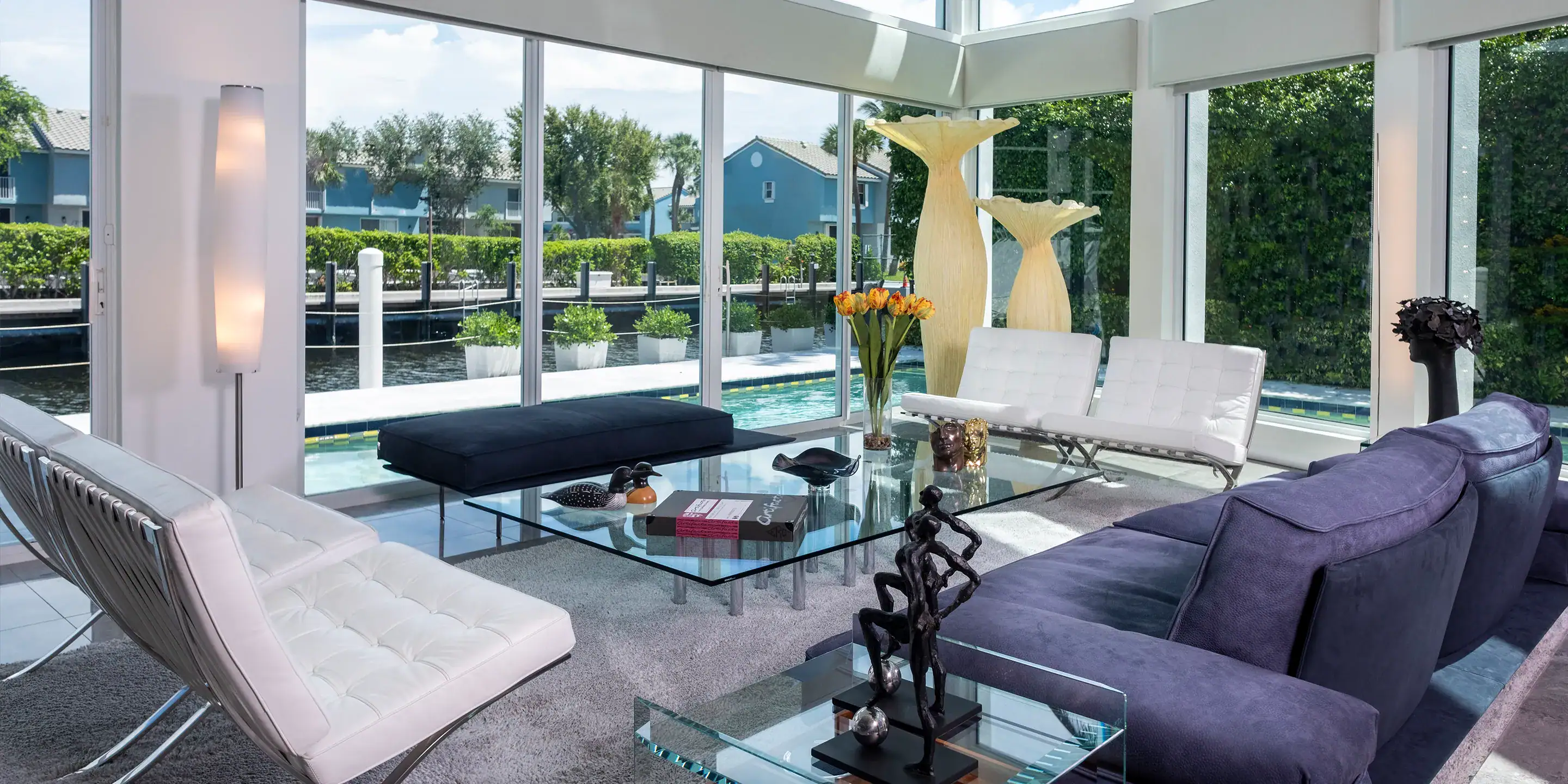 A living room with large windows and furniture.