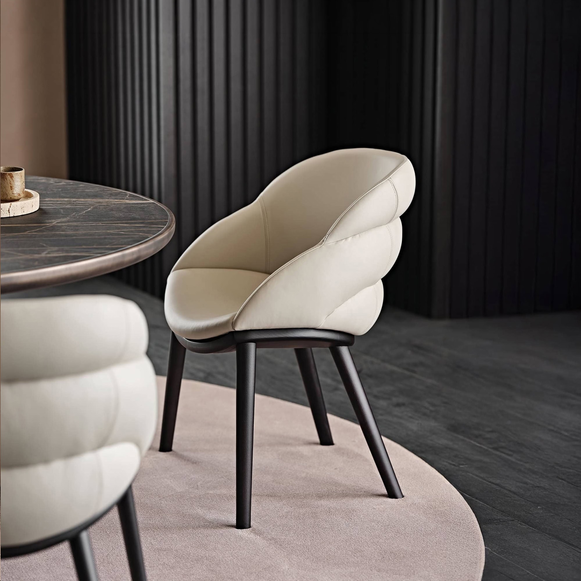 Elegant Camilla upholstered dining chair with curved design and black wooden legs.