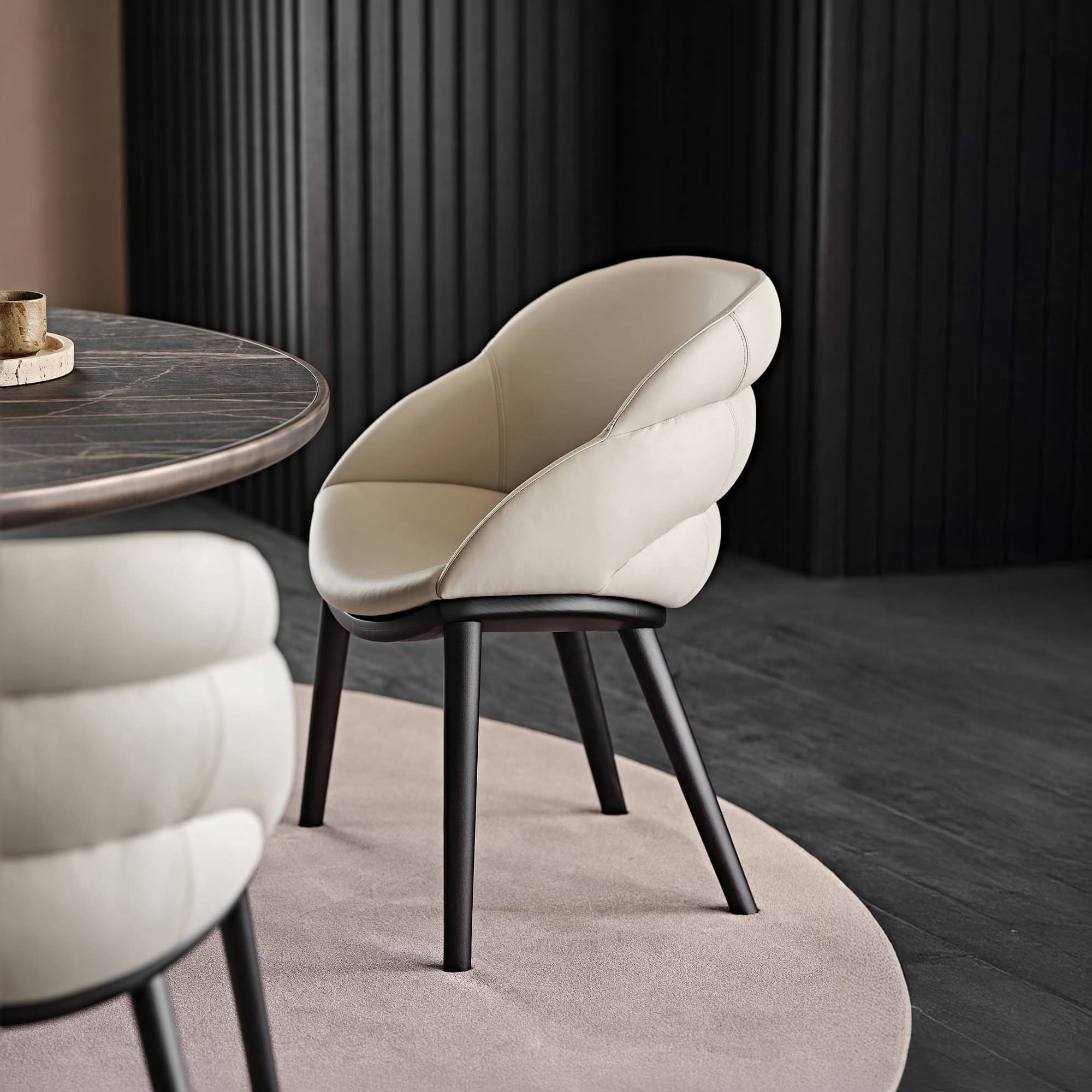 Elegant Camilla upholstered dining chair with curved design and black wooden legs.