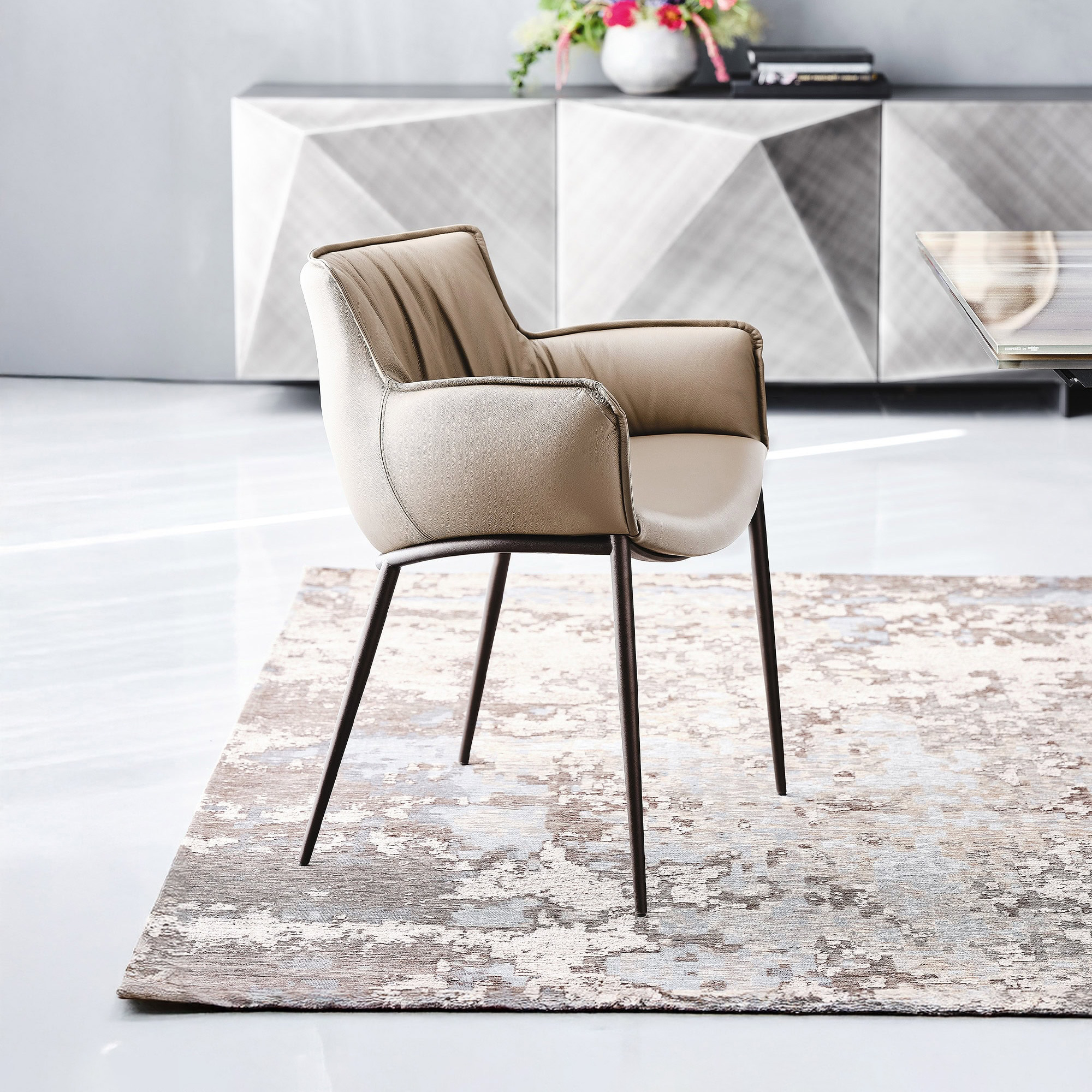 Rhonda Dining Chair in light beige leather with soft upholstery and bronze finish legs.