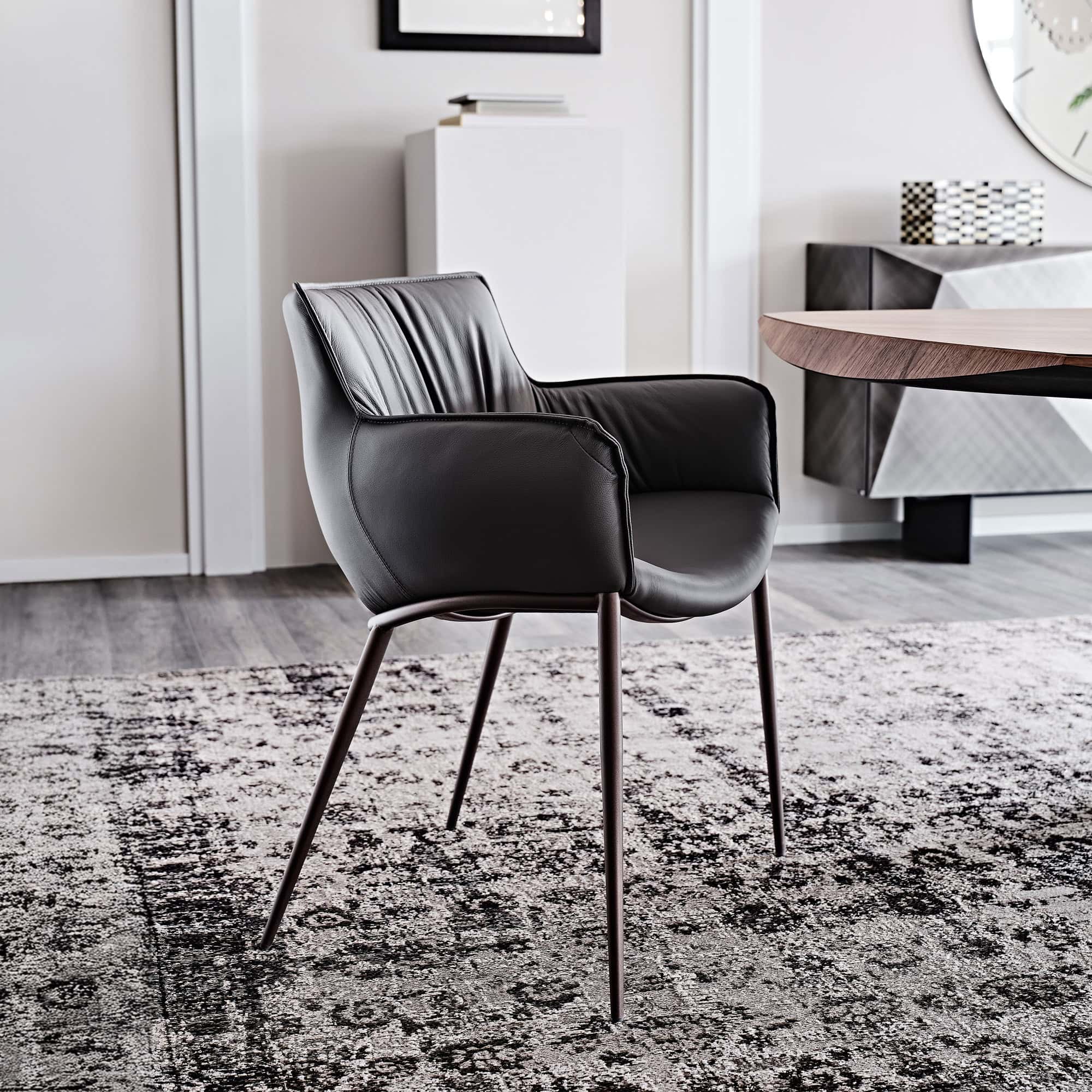 Rhonda Dining Chair in soft taupe leather with slim metal legs, shown in a modern dining room.