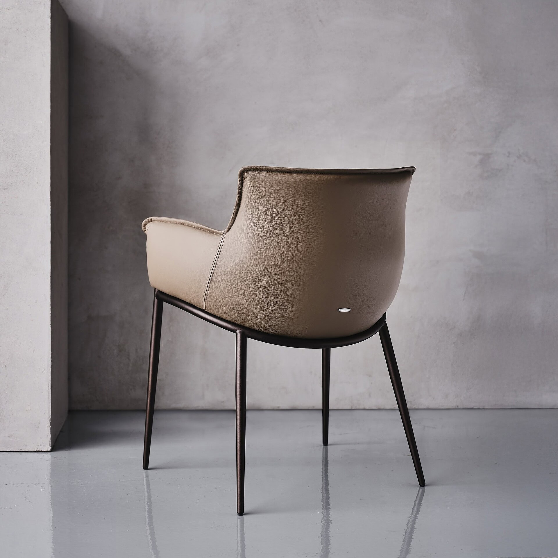 Side profile of the Rhonda Dining Chair in neutral leather against a minimalist backdrop.
