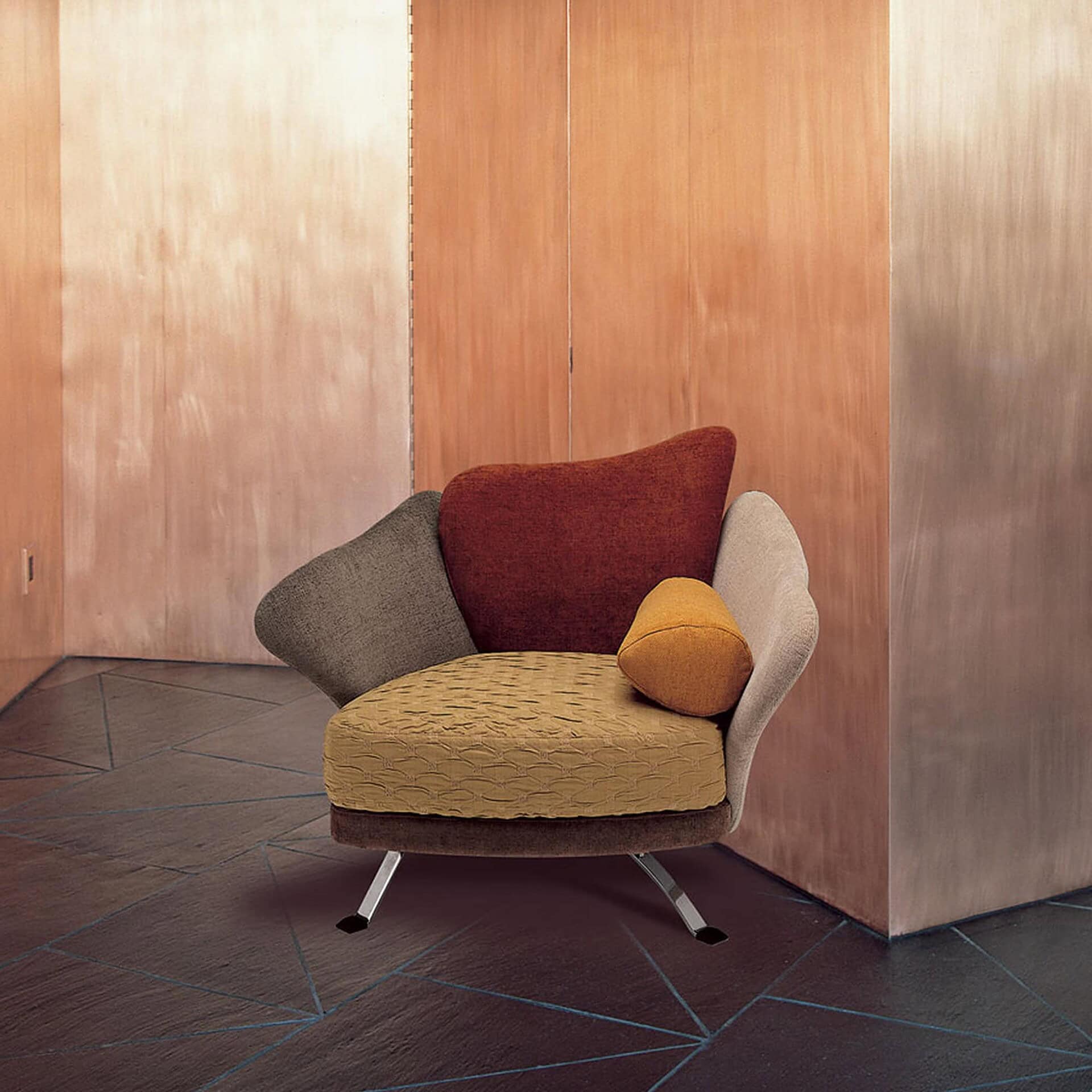 Flower Armchair in mustard yellow and brown fabric with red and gold accent pillows, styled against a warm wood-paneled wall