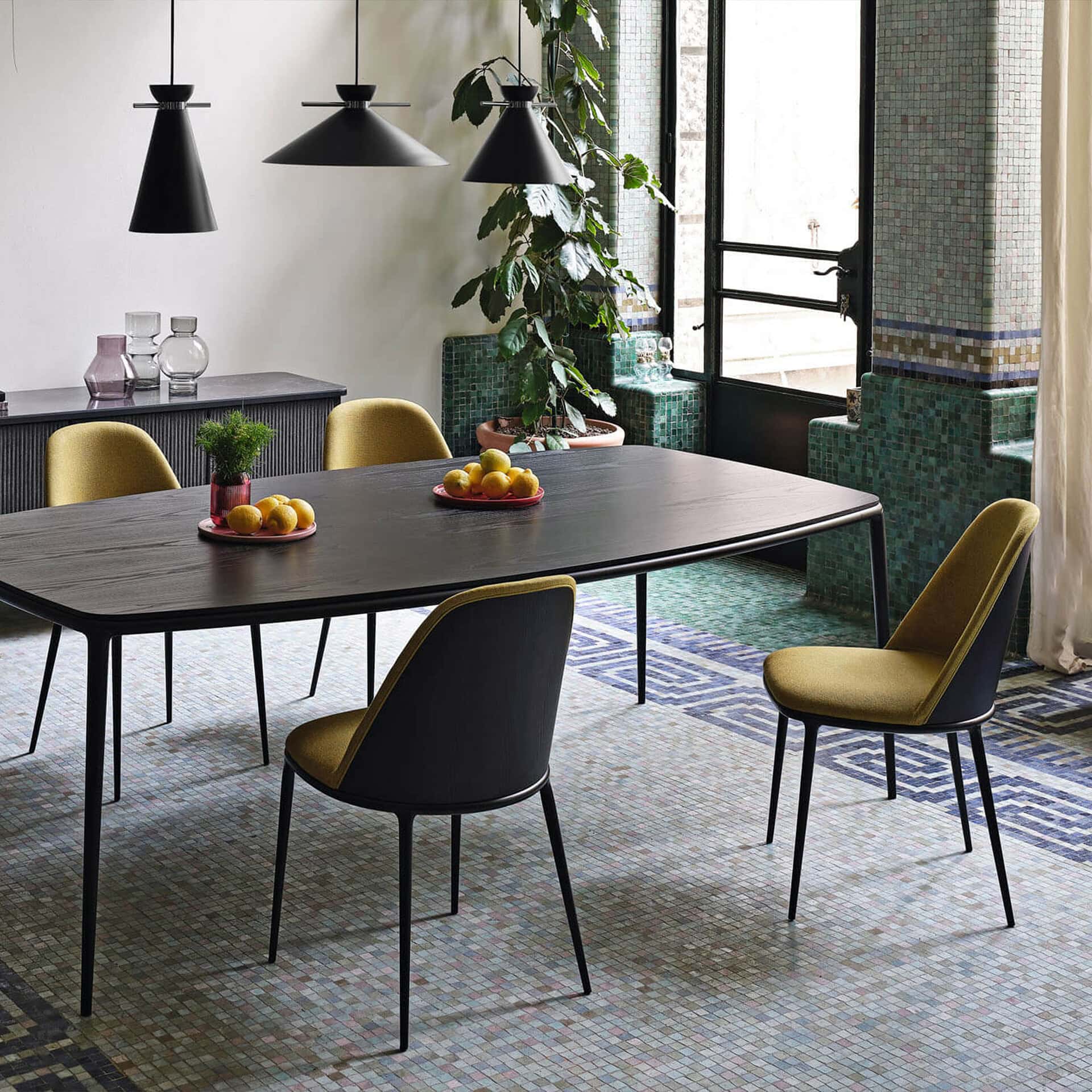 Modern dining room with stylish chairs and pendant lighting.