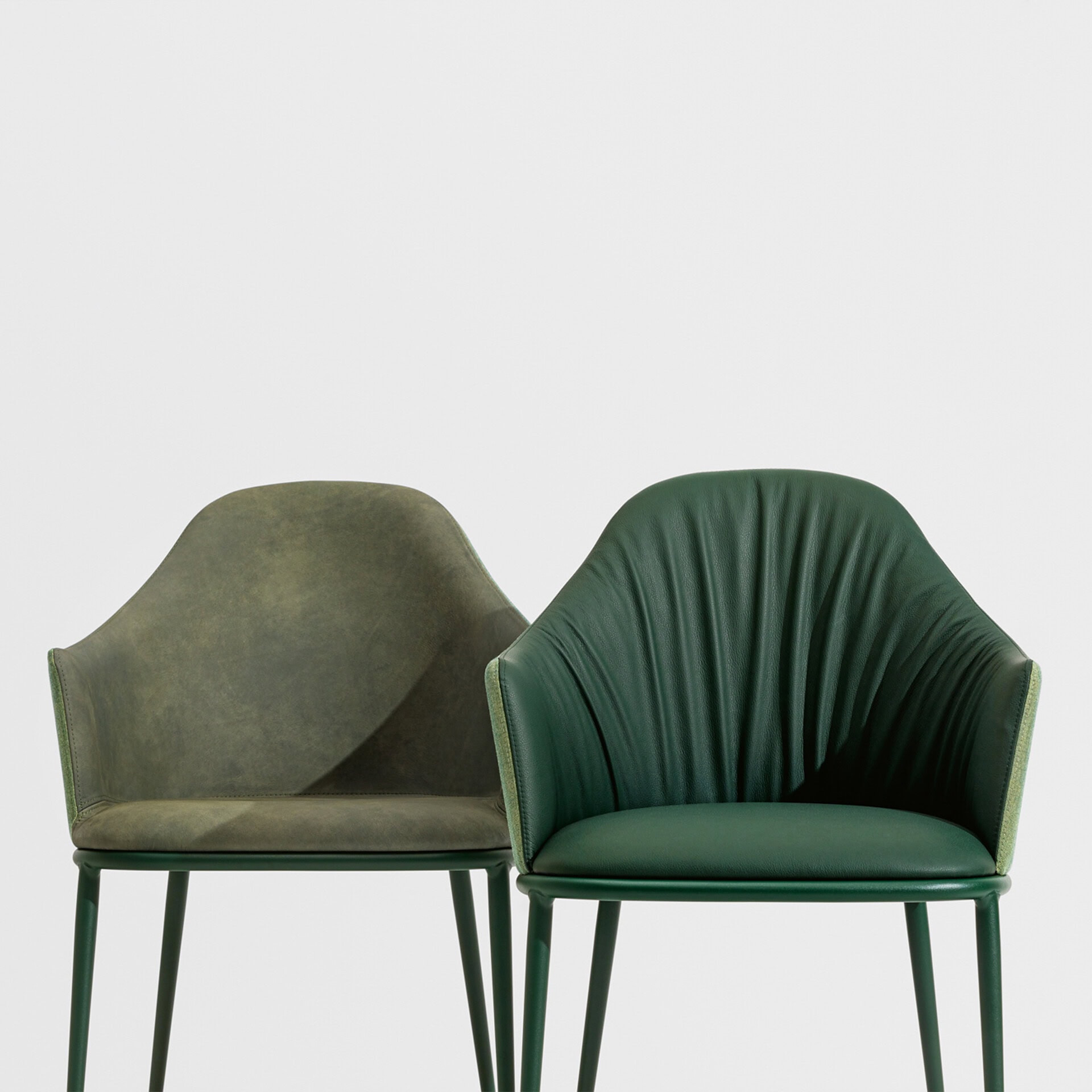 Elegant green upholstered chairs with sleek design and metal legs.