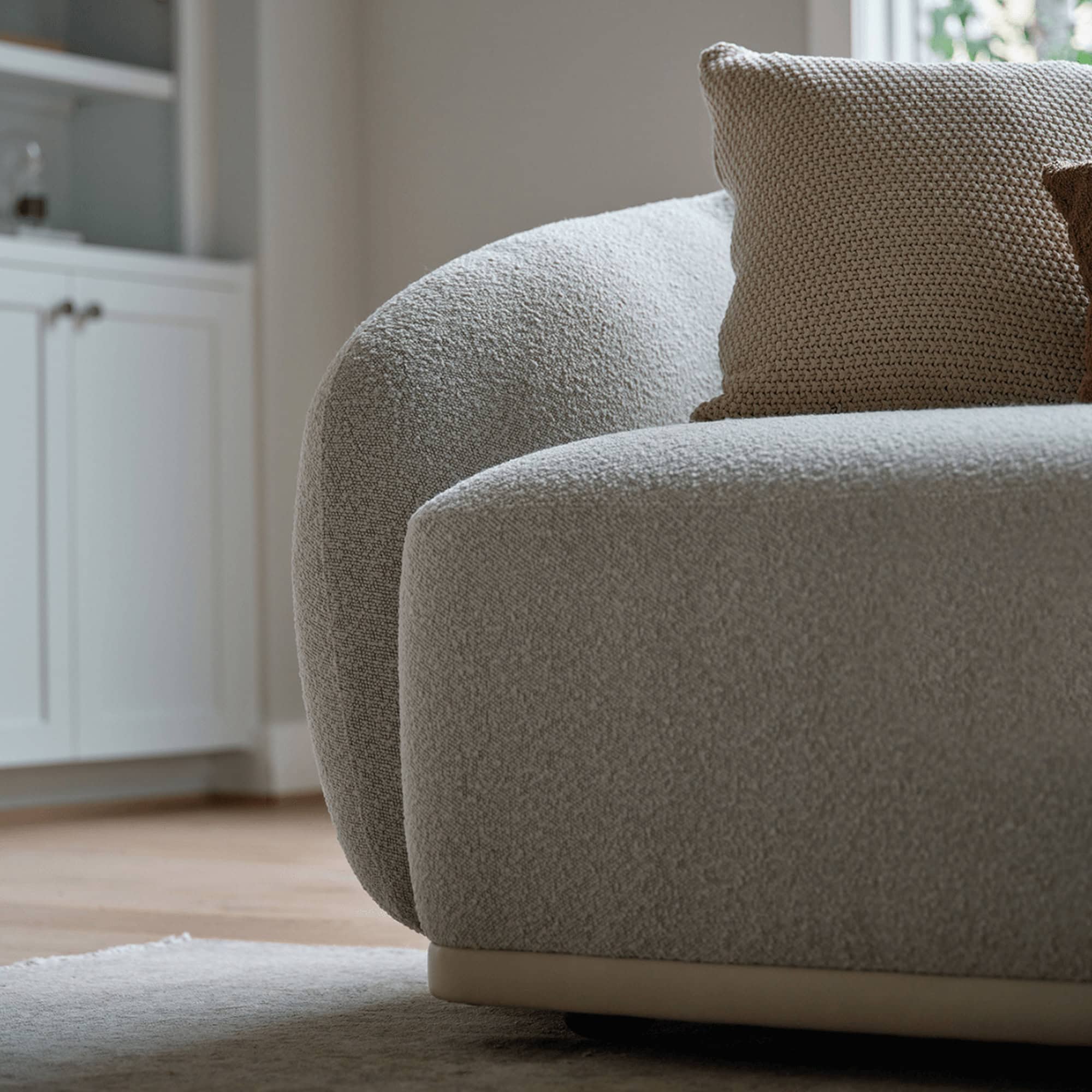 Detail view of the Athlea Sofa’s rounded armrest and smooth upholstery finish.