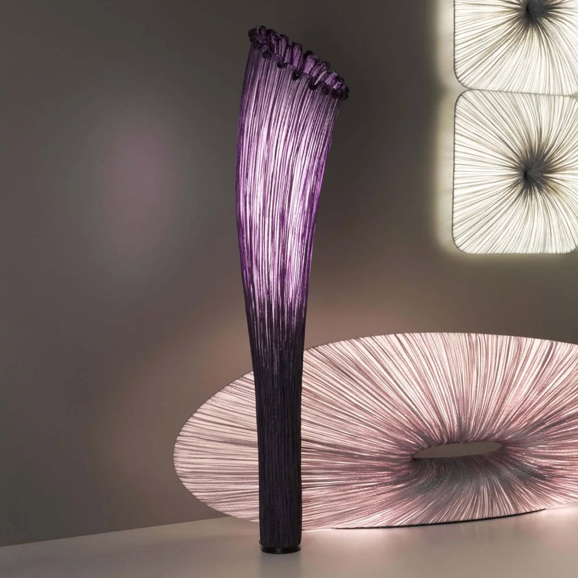 Horn Floor Lamp by Aqua Creations in purple silk shade, glowing softly in a modern setting.