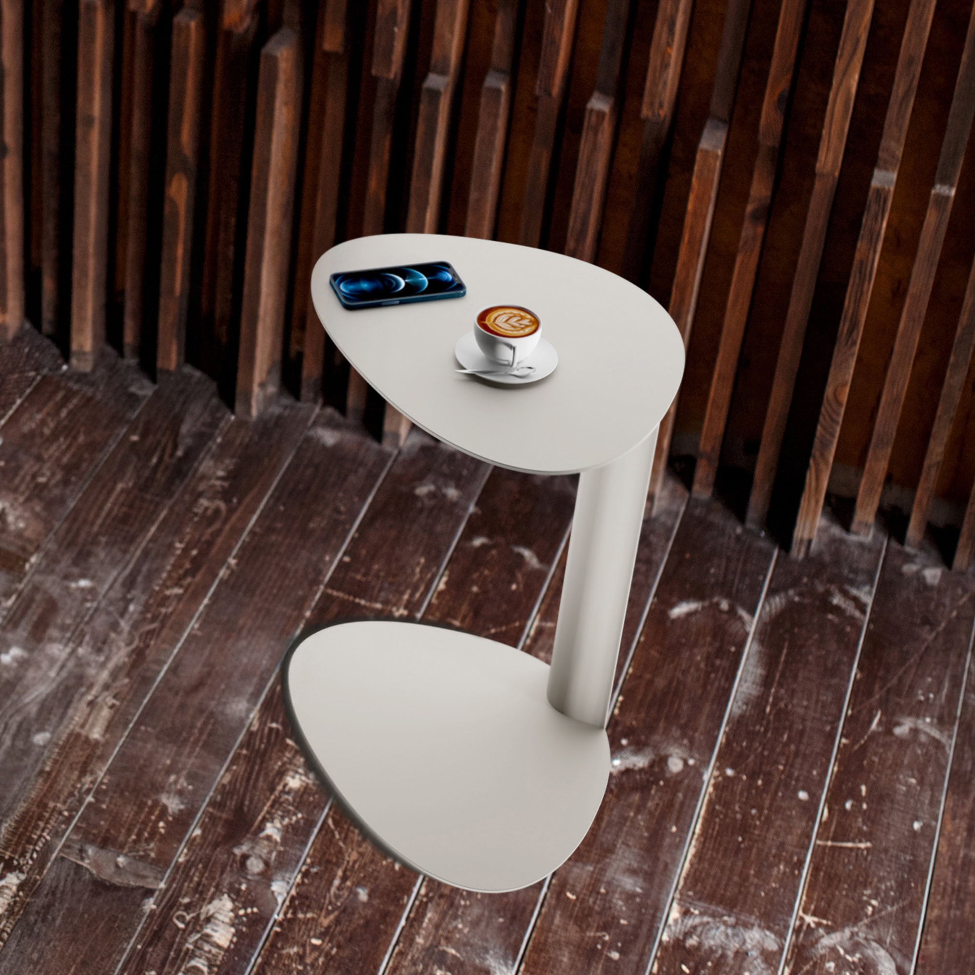 Modern white side table with coffee and phone on wooden deck.