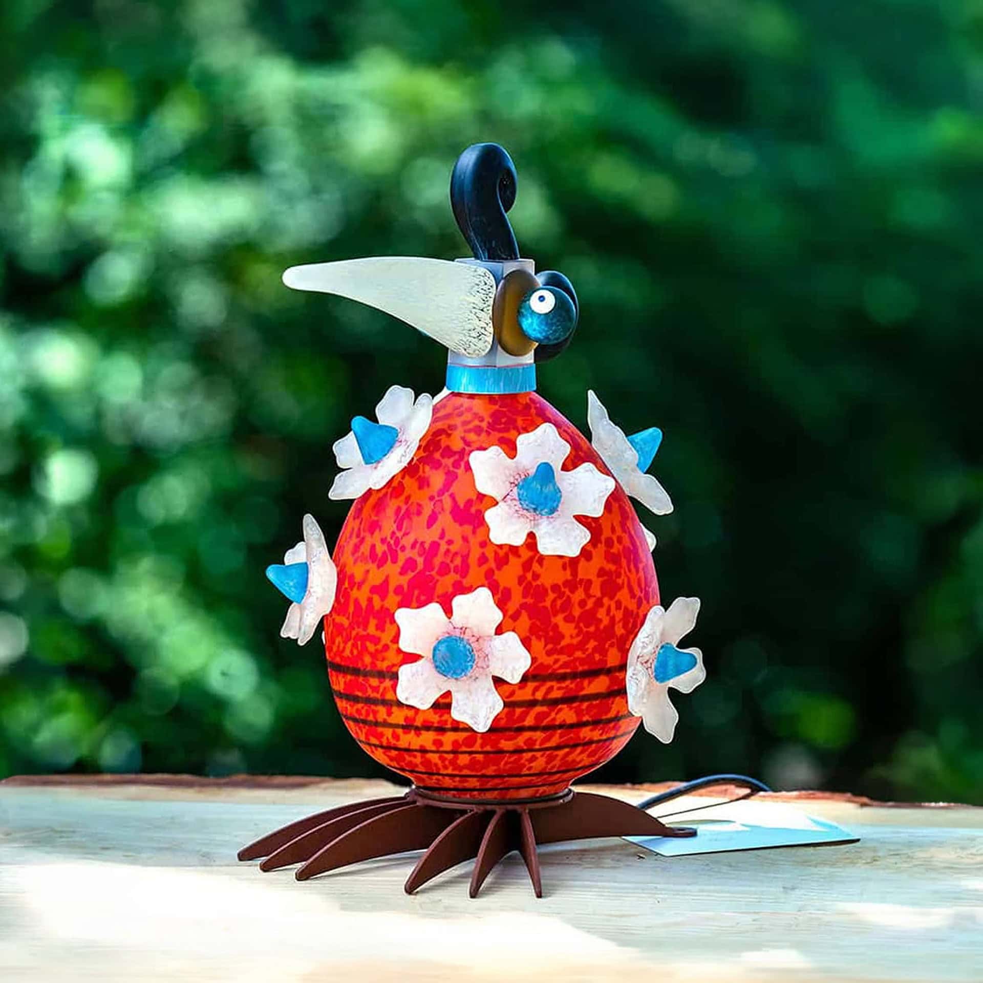 Whimsical bird-shaped outdoor light sculpture with colorful floral accents, perfect for garden decor.
