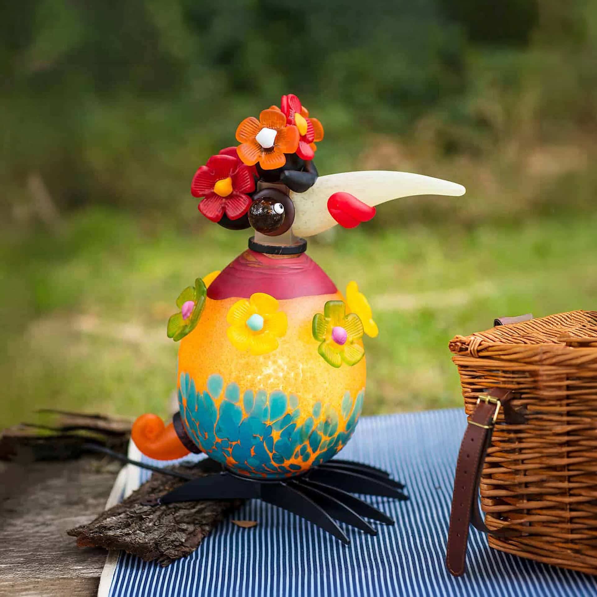 Colorful outdoor bird sculpture with floral accents, perfect for garden lighting and whimsical outdo.