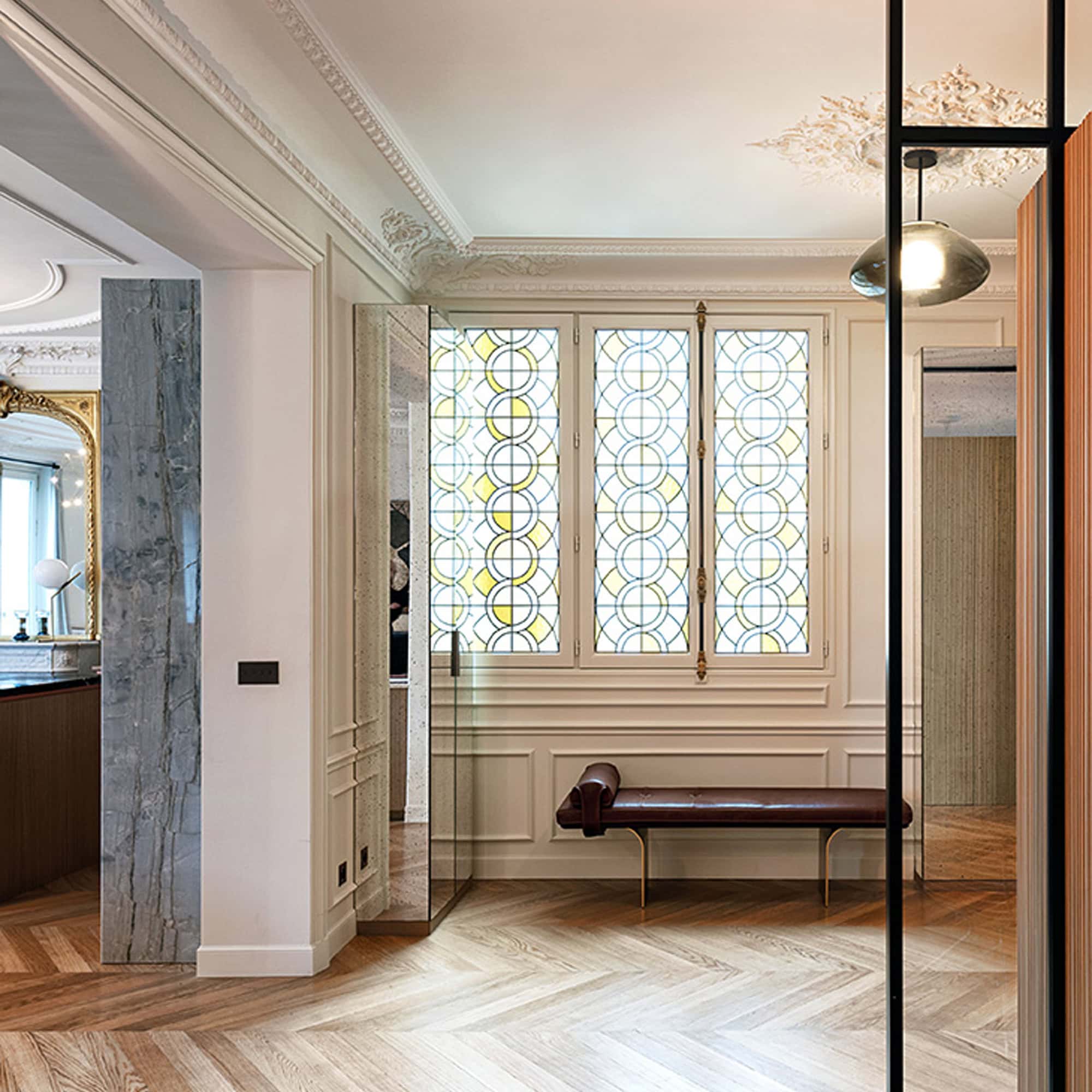 Elegant Minerva Leather Bench in a classic interior with decorative windows and wood flooring.
