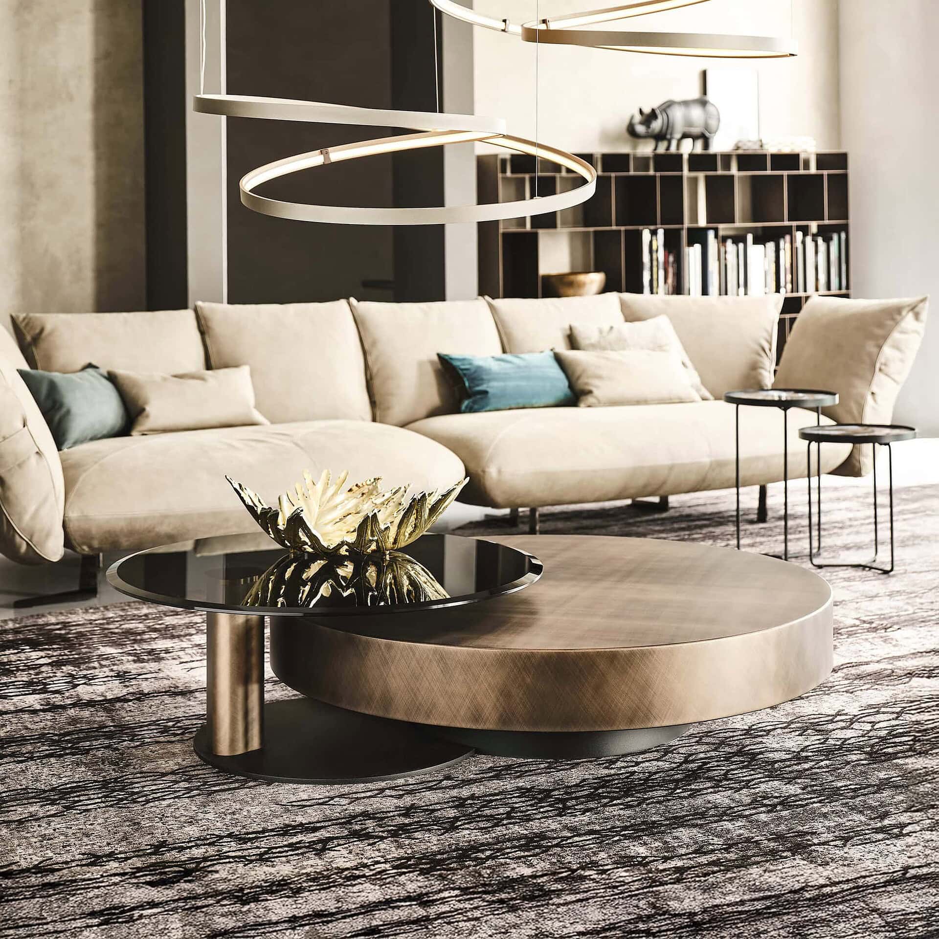 Arena Hand-Brushed Coffee Table with brushed bronze top and black steel base styled in a modern living room with neutral décor.