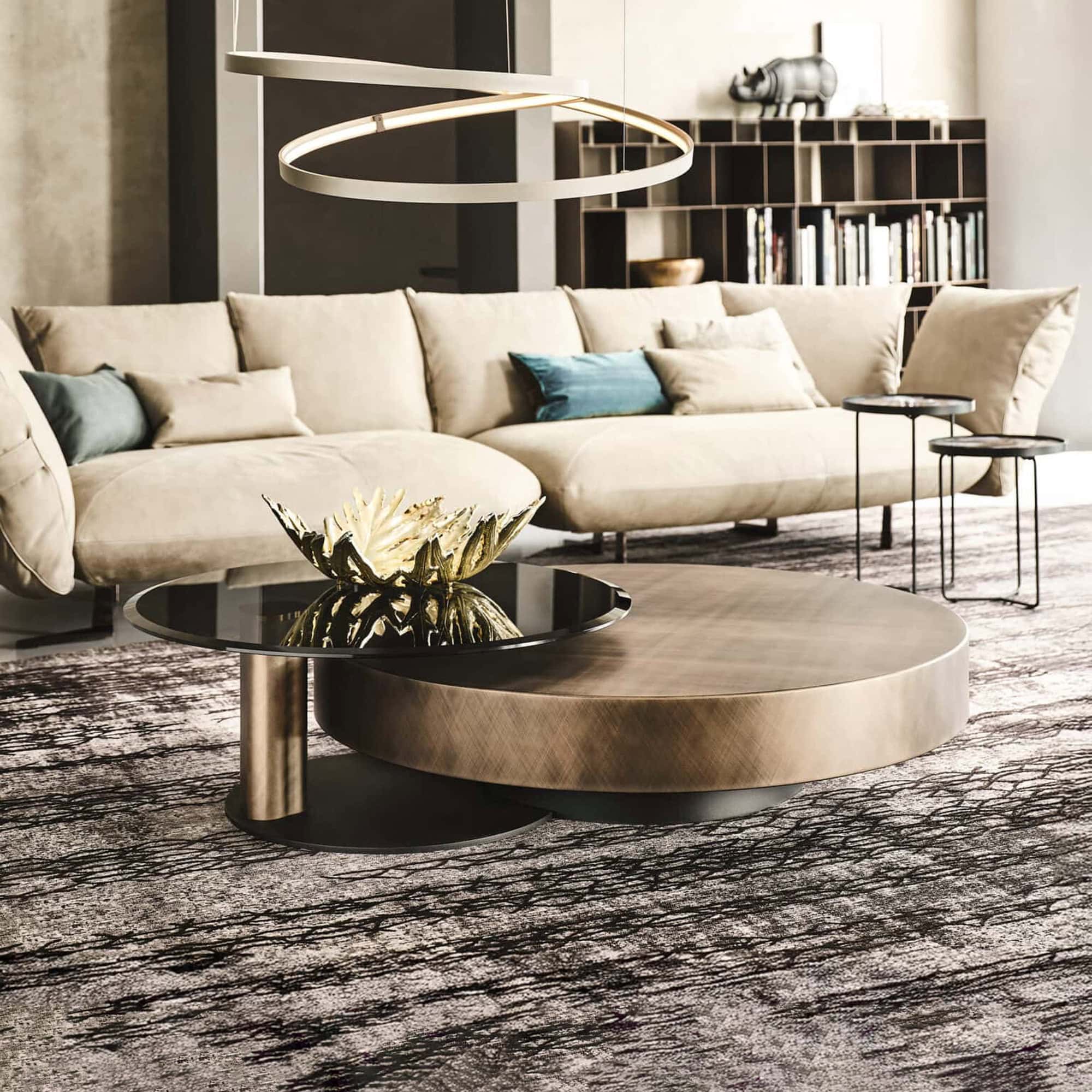 Arena Hand-Brushed Coffee Table with brushed bronze top and black steel base styled in a modern living room with neutral décor.