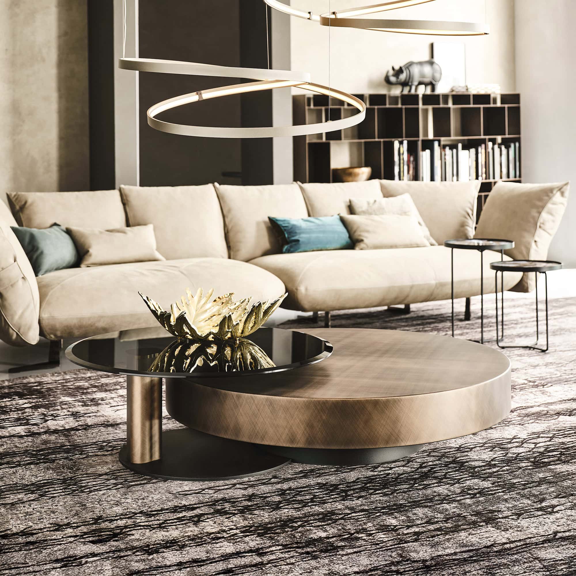 Arena Hand-Brushed Coffee Table with brushed bronze top and black steel base styled in a modern living room with neutral décor.