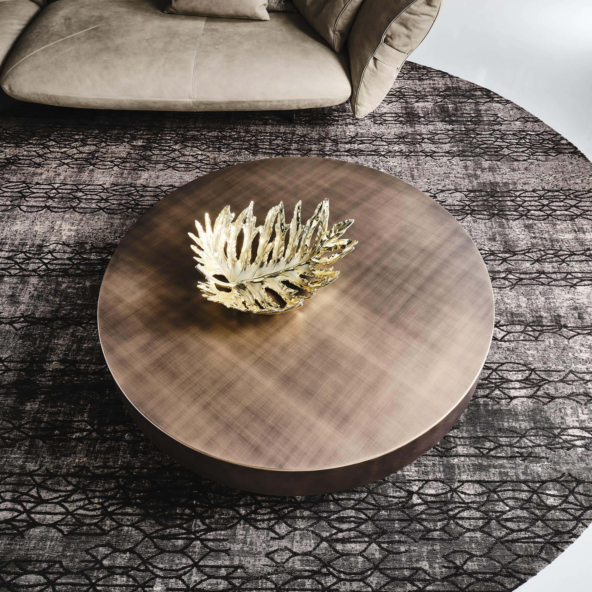 Arena Hand-Brushed Coffee Table in a round design with brushed bronze top set against a colorful modern backdrop.