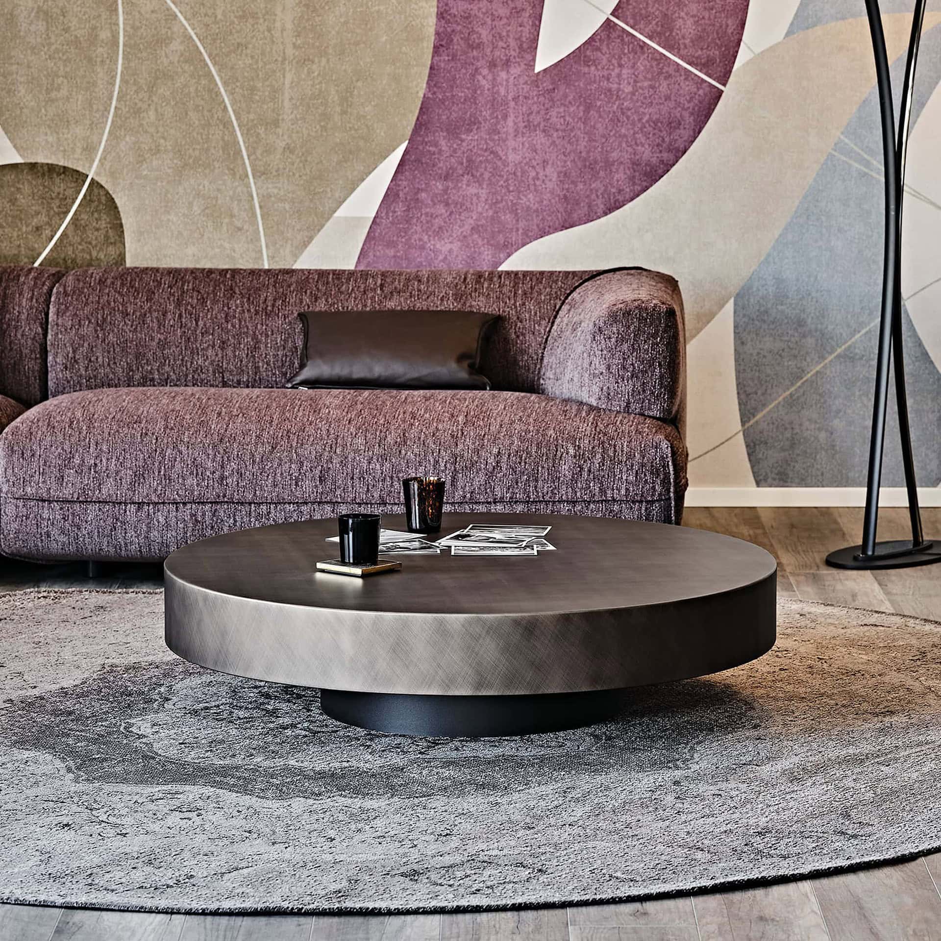 Arena Hand-Brushed Coffee Table in brushed bronze finish styled with a sectional sofa and patterned rug.