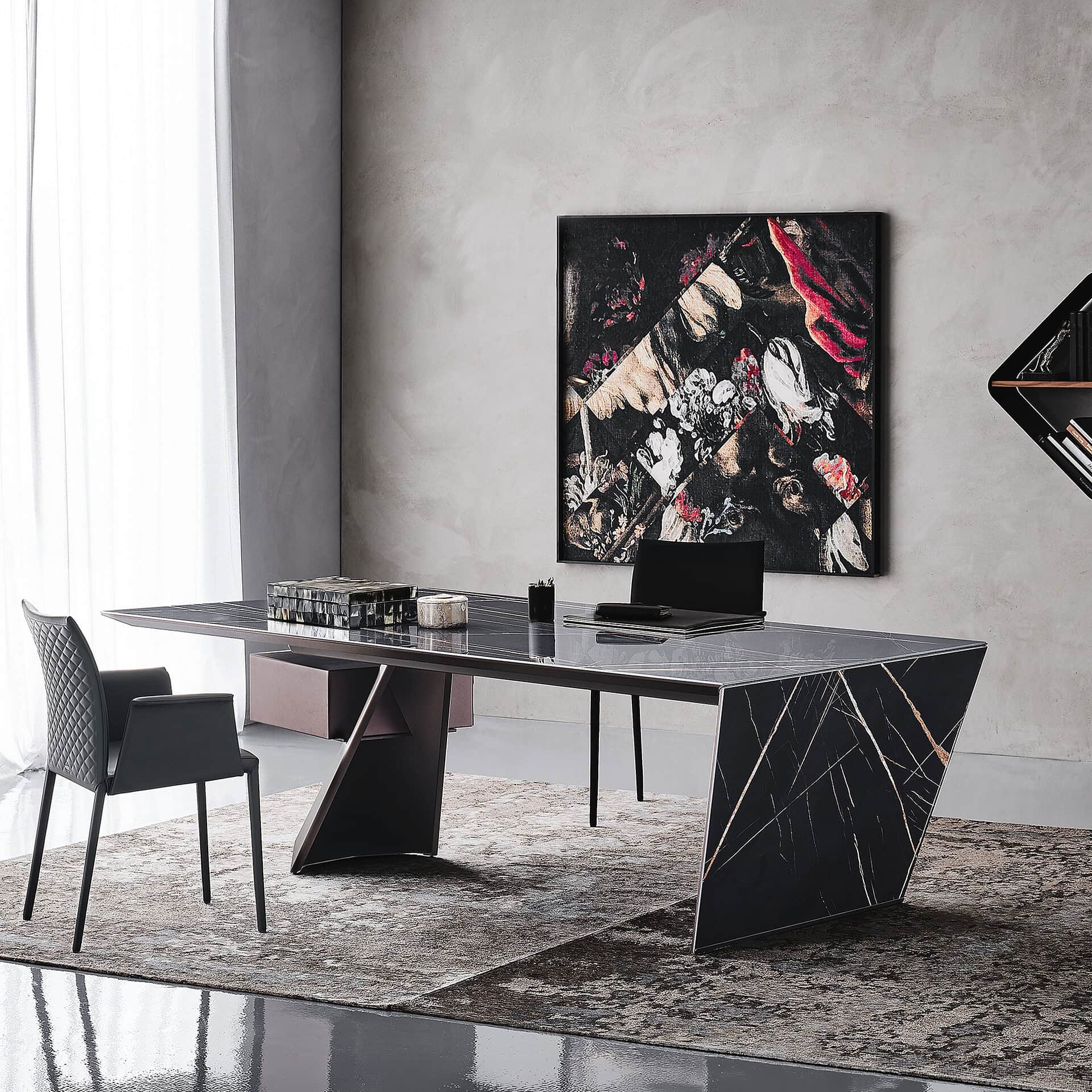 Black marble conference table with artistic wall art in a contemporary office setting.