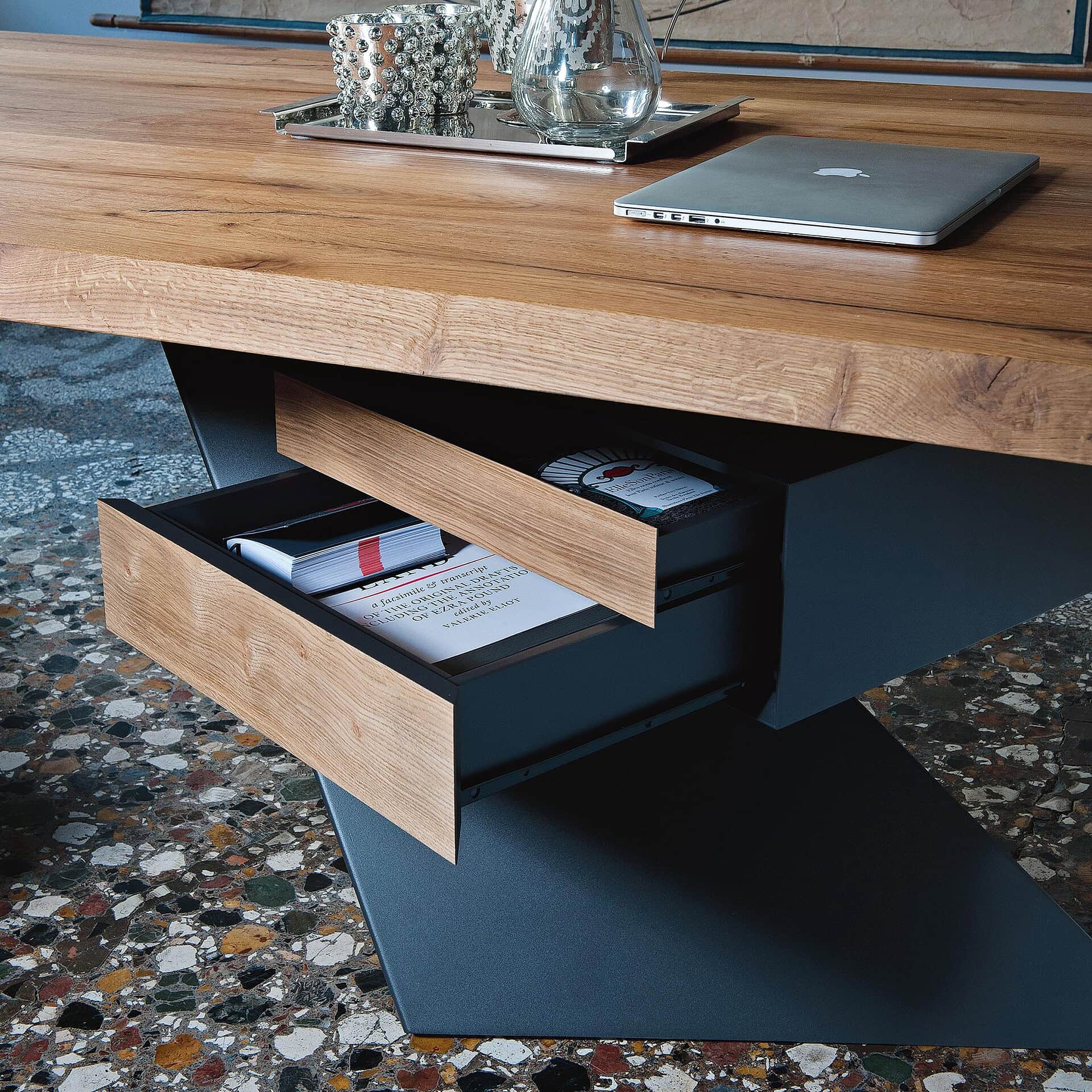 Stylish wooden desk with open drawers and a laptop, perfect for modern office or workspace setups.