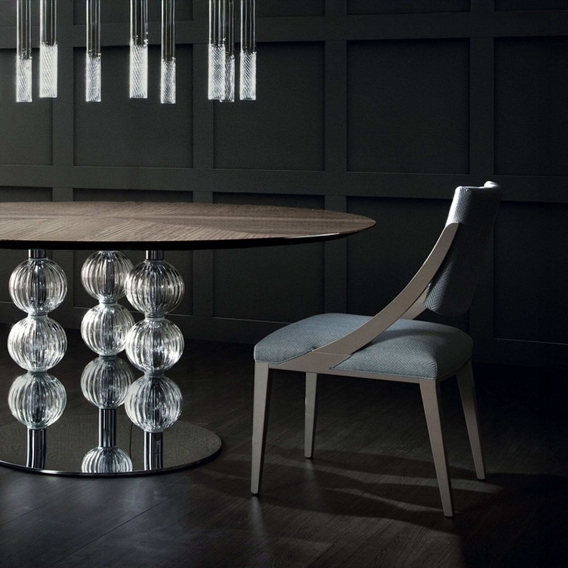 Elegant modern dining table with a glass sphere base and a wooden top, paired with a stylish upholst.