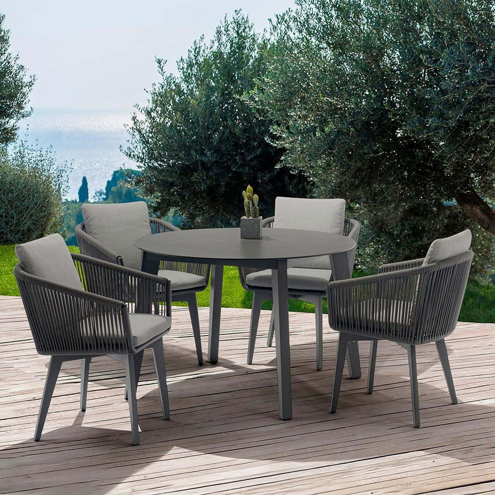 Stylish outdoor dining table with six cushioned chairs on a wooden deck.