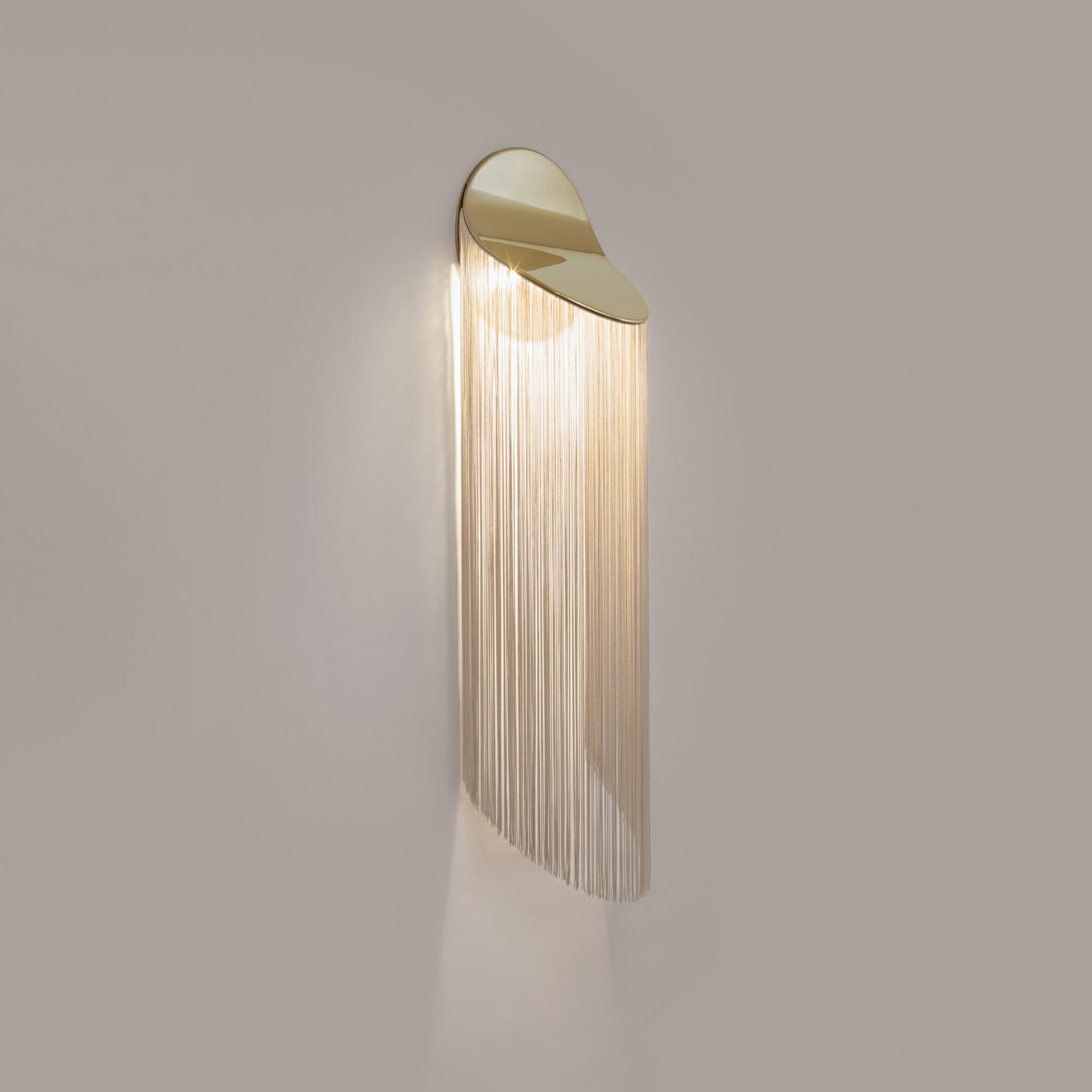 Elegant modern gold wall sconce with cascading metal fringe design.