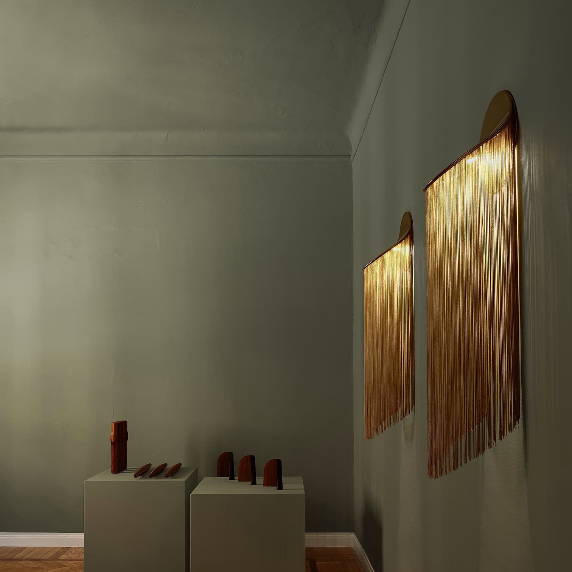 Elegant wall sconces with gold fringe lighting, enhancing modern interior decor.