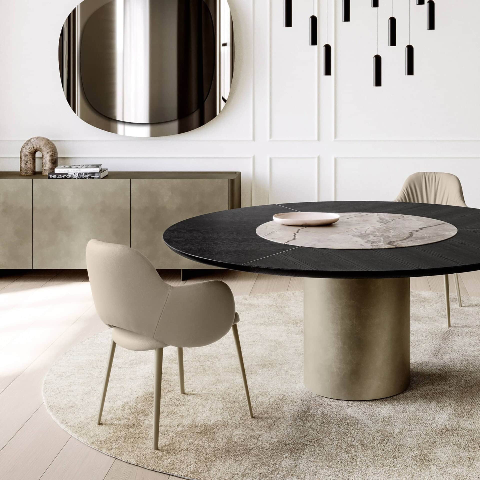 Pair of Silhouette Deluxe Upholstered Dining Chairs in beige fabric with slim gold legs, set around a round black dining table with a brass pedestal base.