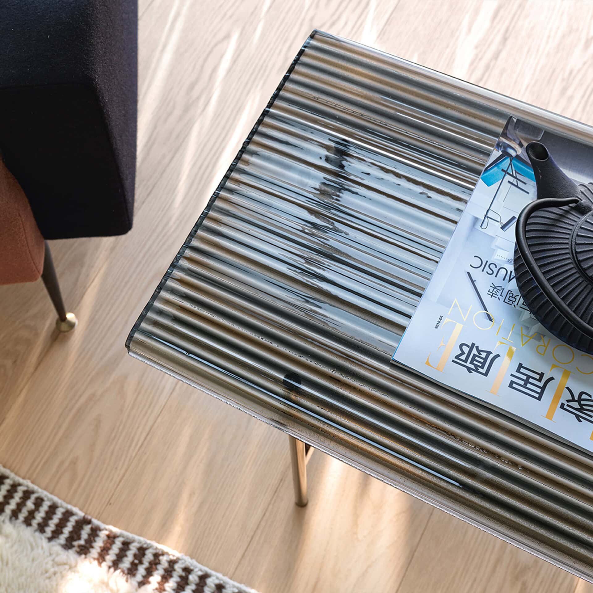 Metallic side table with glass top in contemporary living room decor.