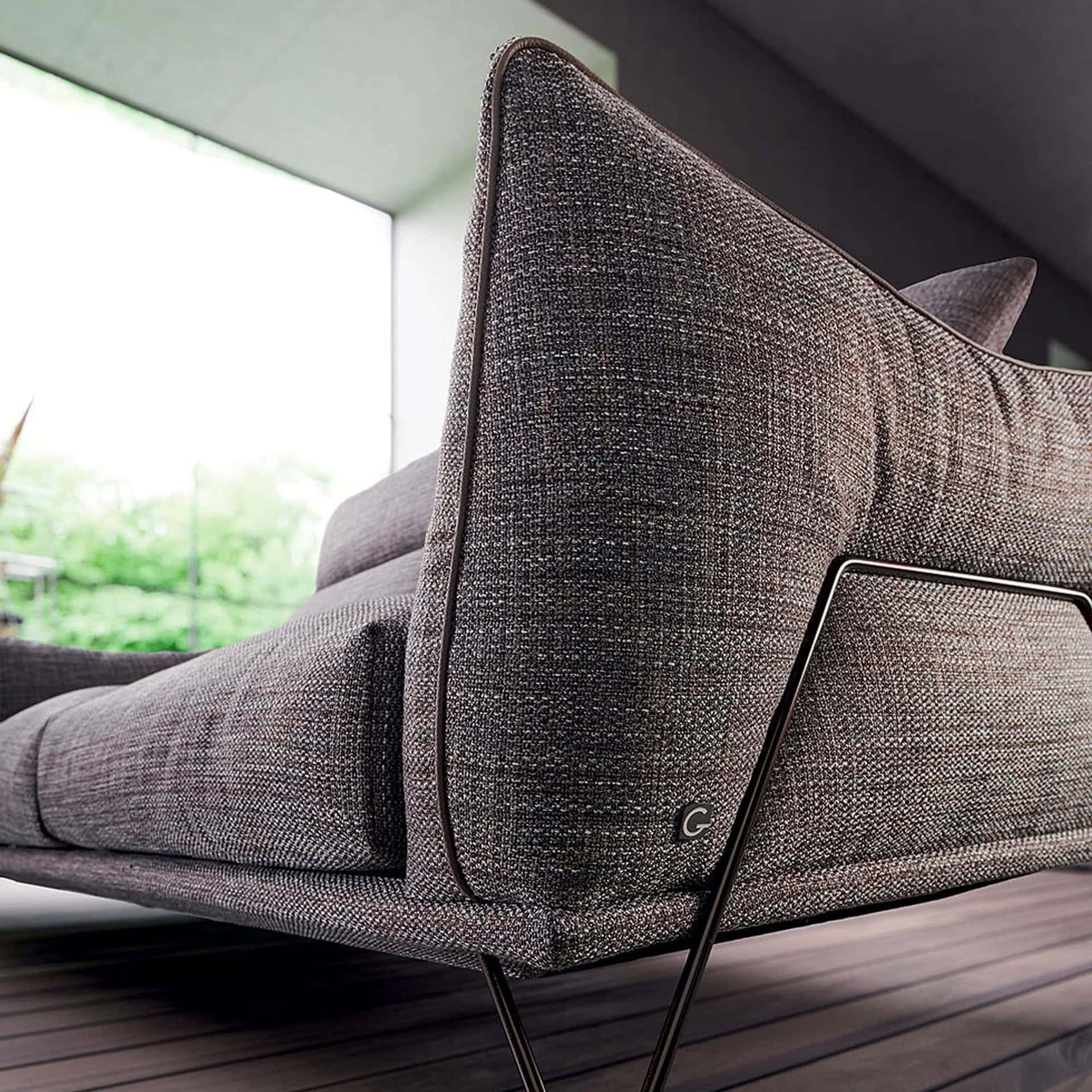 Close-up side view of Dagor Sofa, highlighting detailed upholstery and slim angled legs.