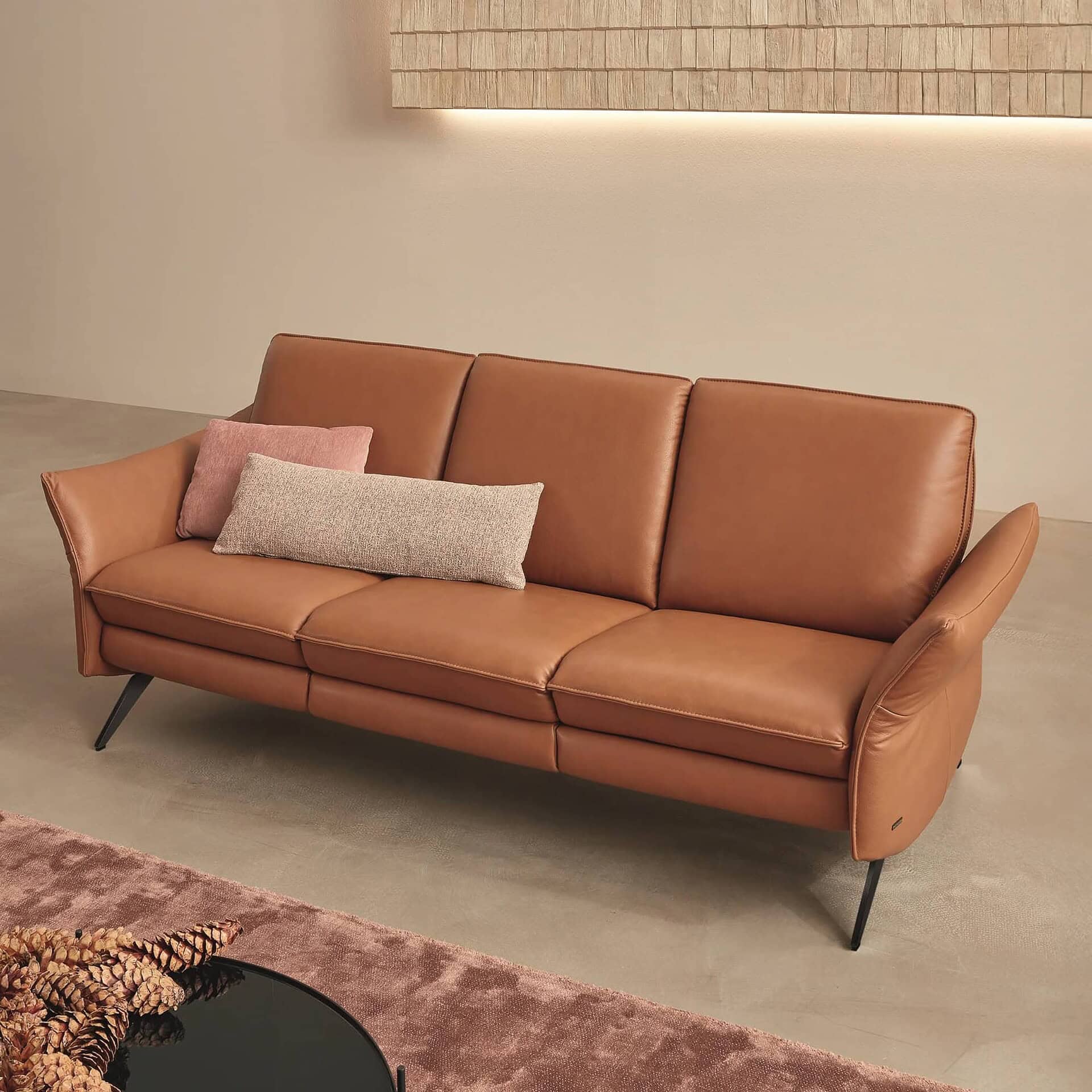 Siegfried 6902 Reclining Sofa in cognac leather with slim metal legs.