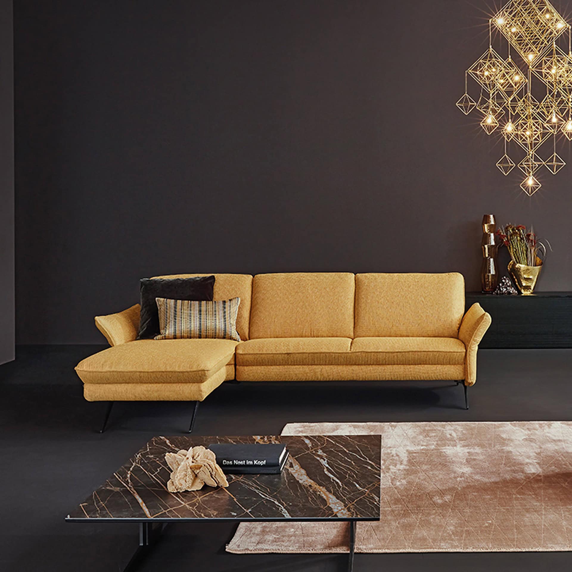 Siegfried 6902 Reclining Sofa in mustard yellow fabric, styled in a dark contemporary space.