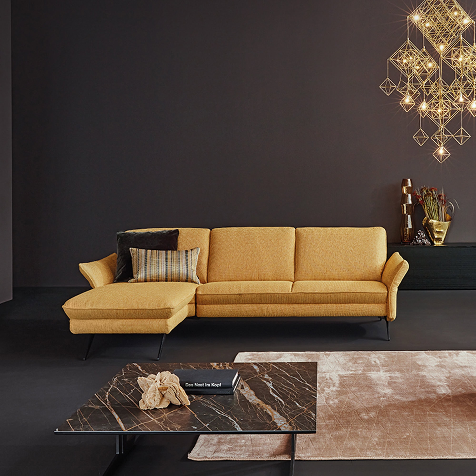 Siegfried 6902 Reclining Sofa in mustard yellow fabric, styled in a dark contemporary space.