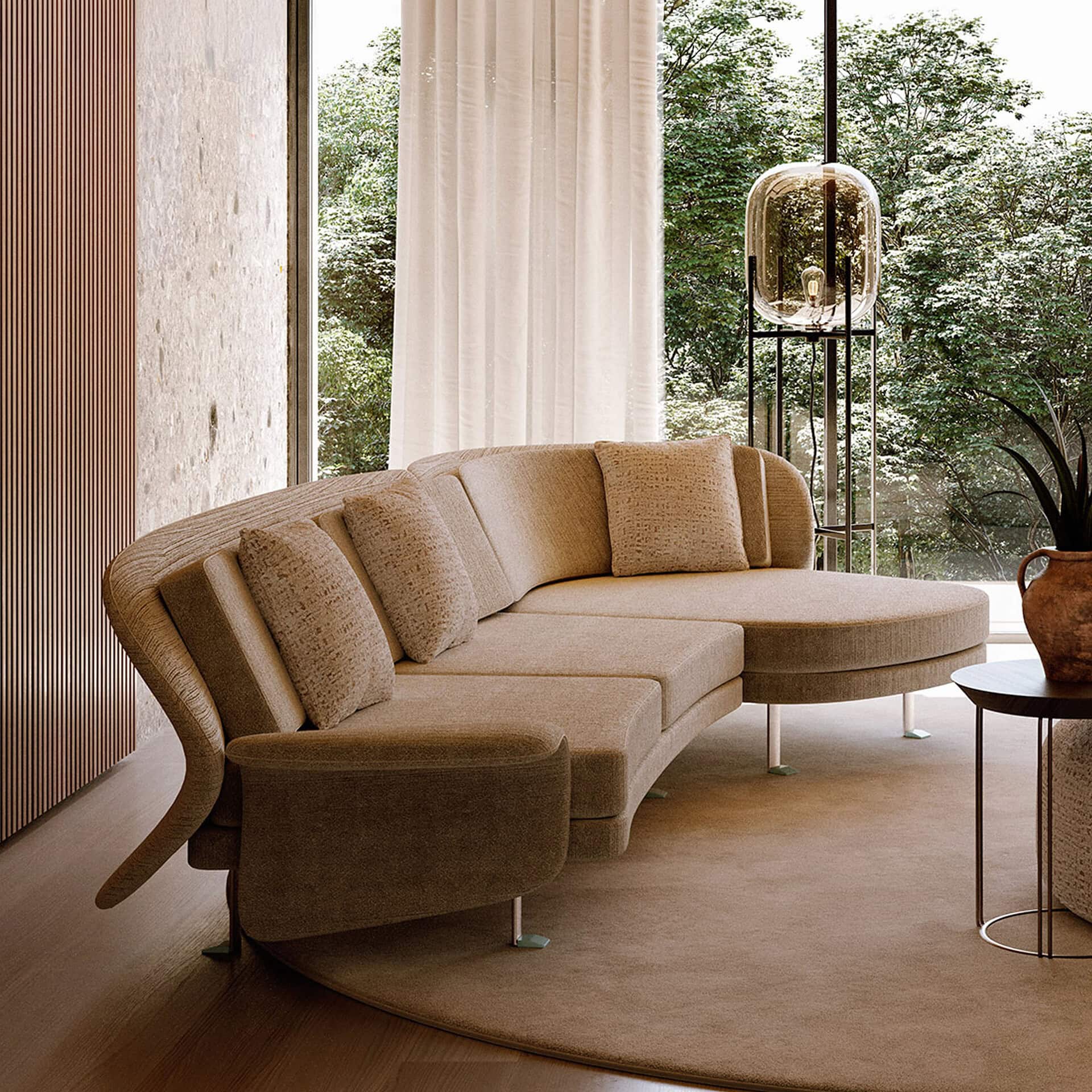 Elegant beige curved sectional sofa with plush cushions in modern living room.