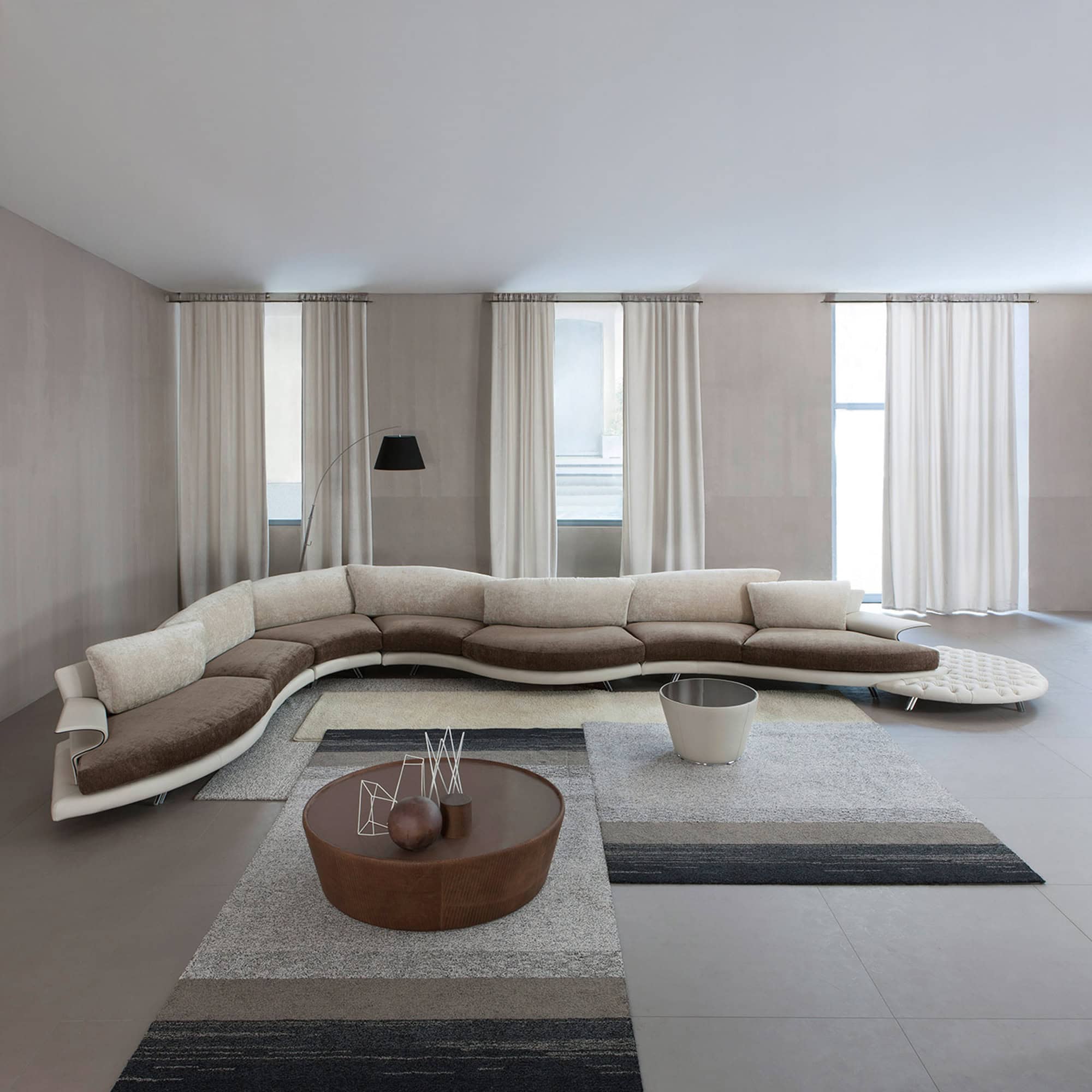 Detail shot of the Super Roy sofa cushions and armrest showing plush upholstery on a tufted leather platform.