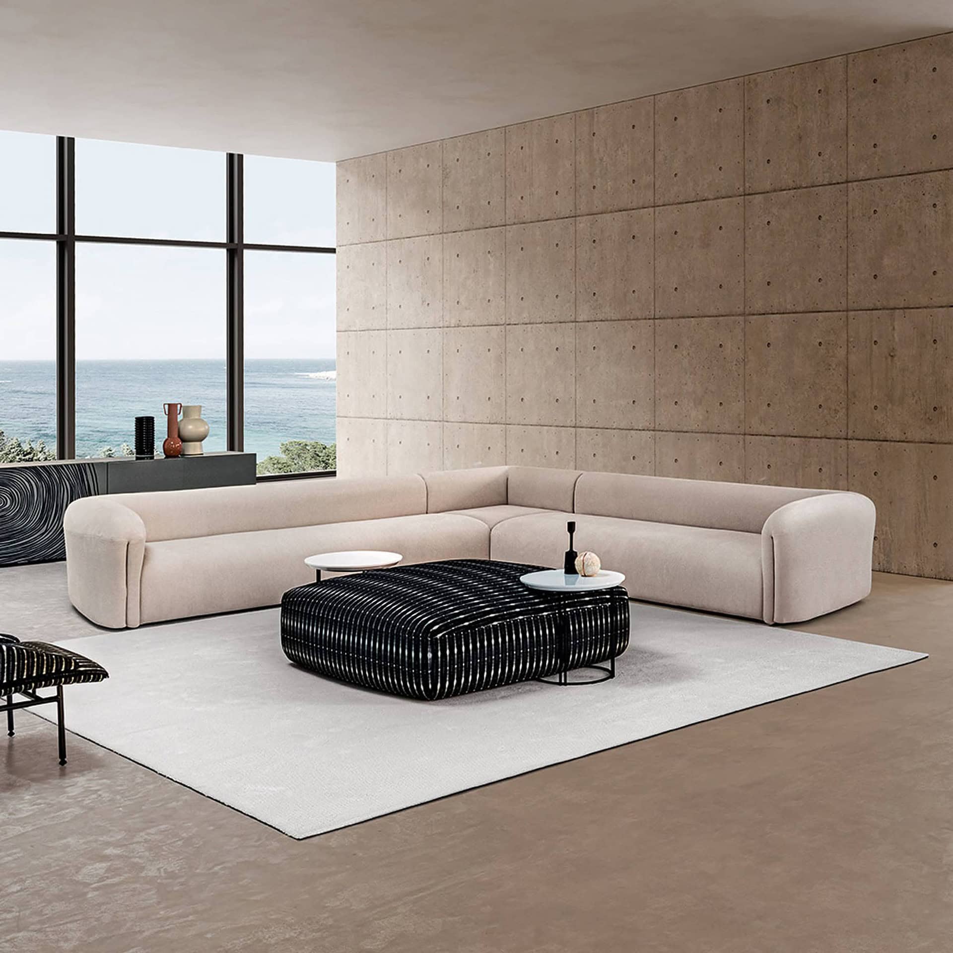 Quentin Angle Sofa in white upholstery with black round coffee table in a minimalist setting.