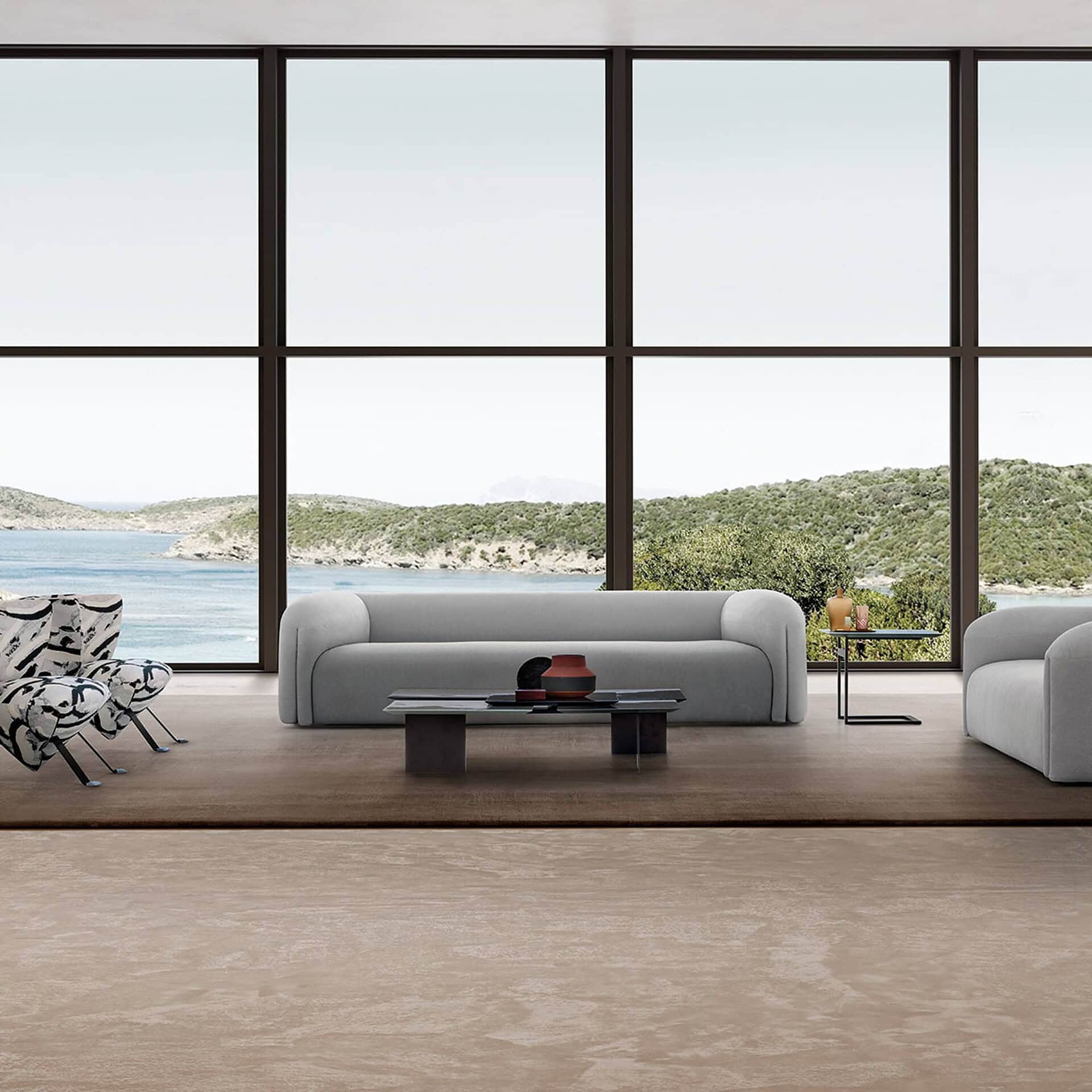 Quentin Linear Upholstered Sofa in neutral grey tones, paired with modern coffee tables in a coastal-inspired interior.