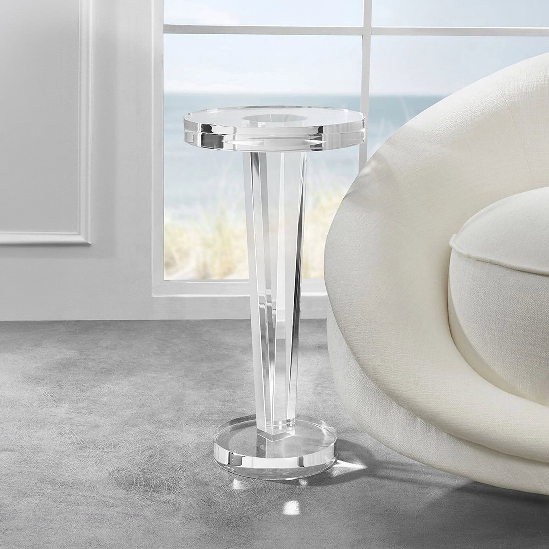 Modern acrylic side table beside a white sofa in a bright living room.