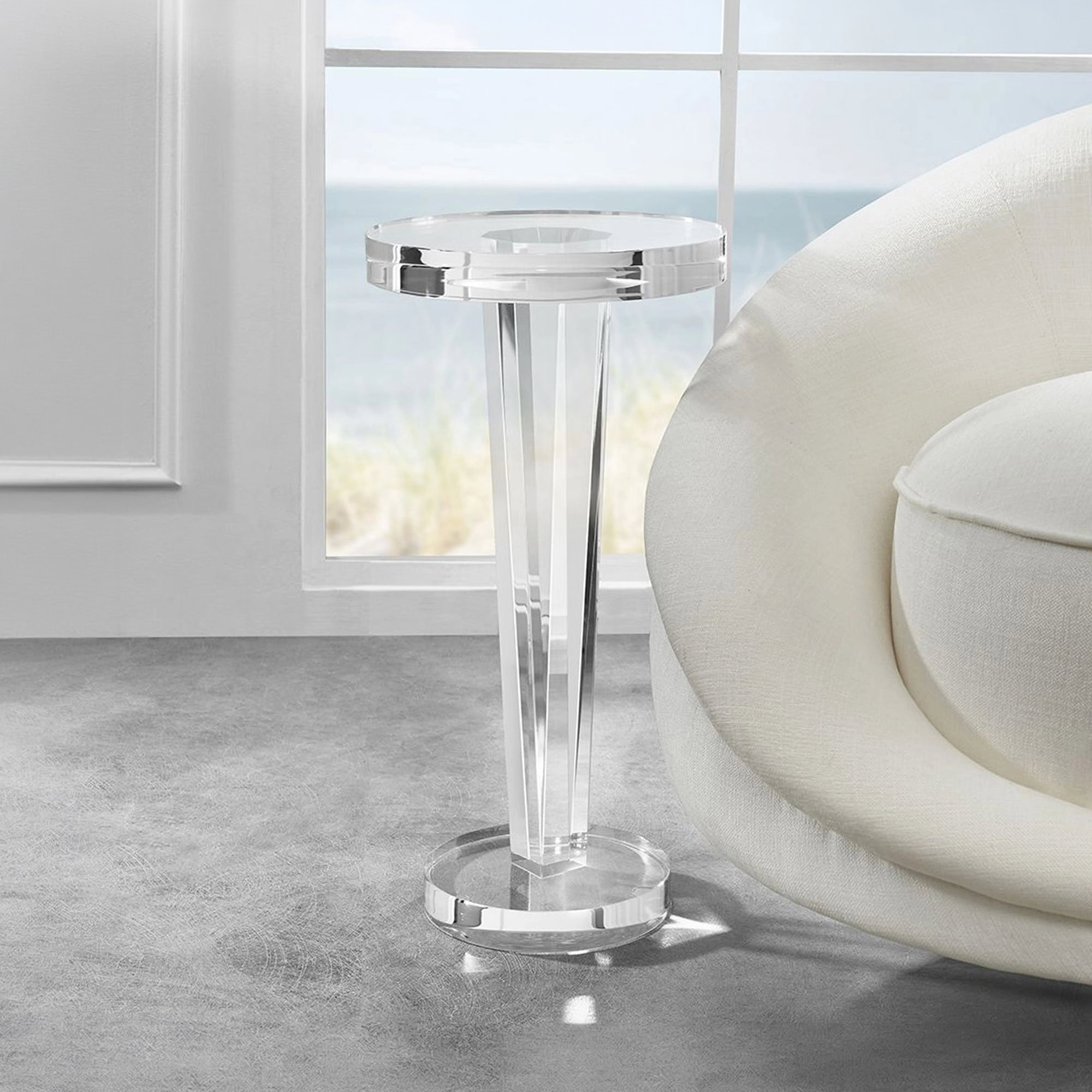 Modern acrylic side table beside a white sofa in a bright living room.
