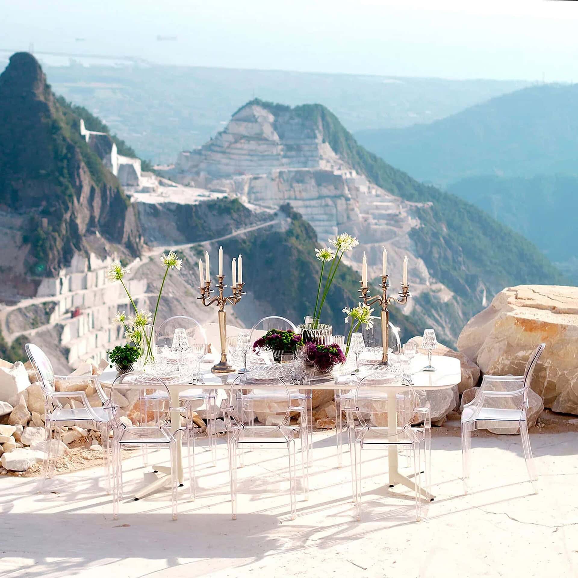 Louis Ghost Chairs on a terrace with mountain views